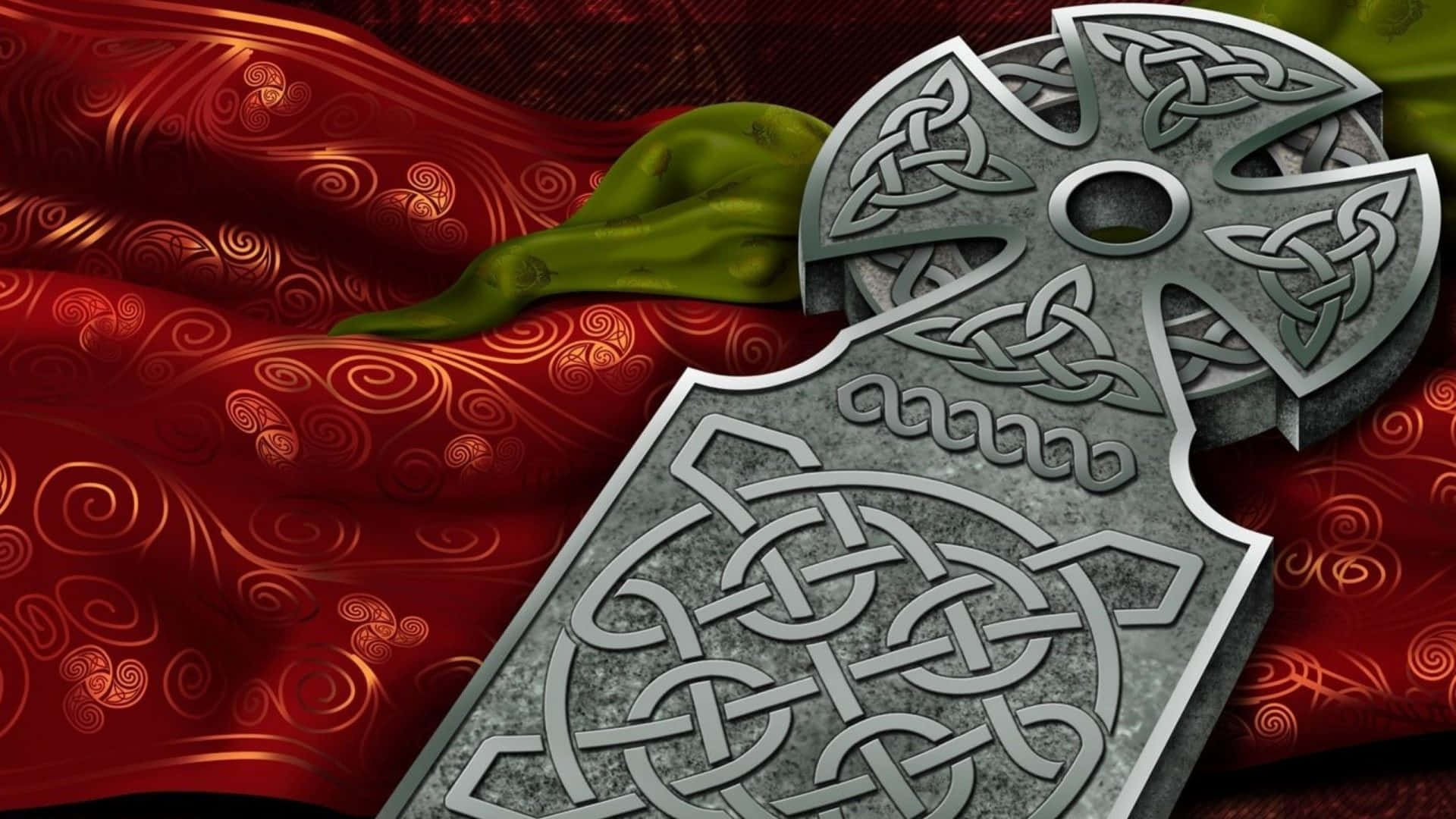 Pagan 桌布 壁紙 — 兩個雕刻精細的凱爾特十字架放在一塊帶有旋轉金色圖案和綠色葉子裝飾的濃郁紅色布料上。