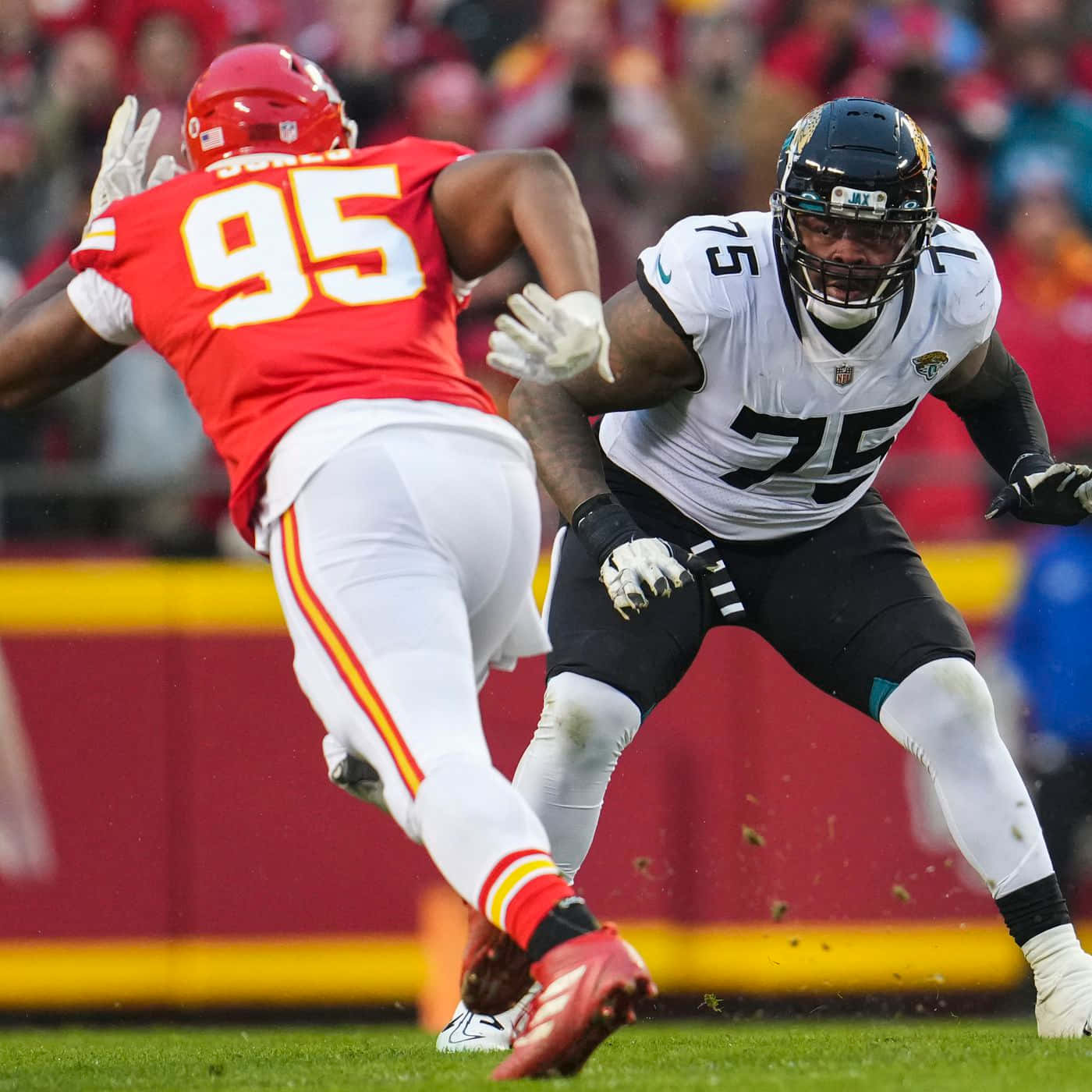 Jawaan Taylor 桌布 壁紙 — 兩名NFL球員在夜間比賽中激烈碰撞，體育場燈光照亮了整個動作。