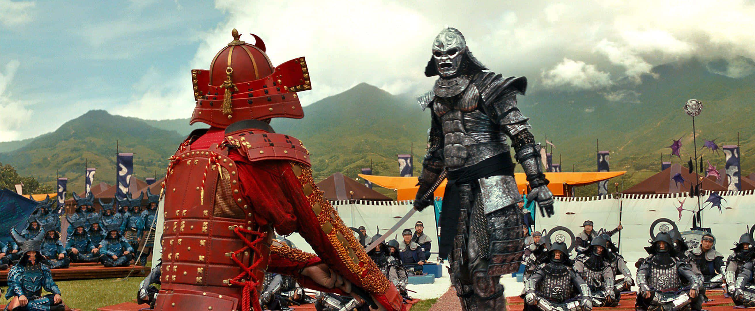 47 Ronin 桌布 壁紙 — 兩名全副武裝的武士在一個多山的戰場上緊張對峙，部隊列陣。