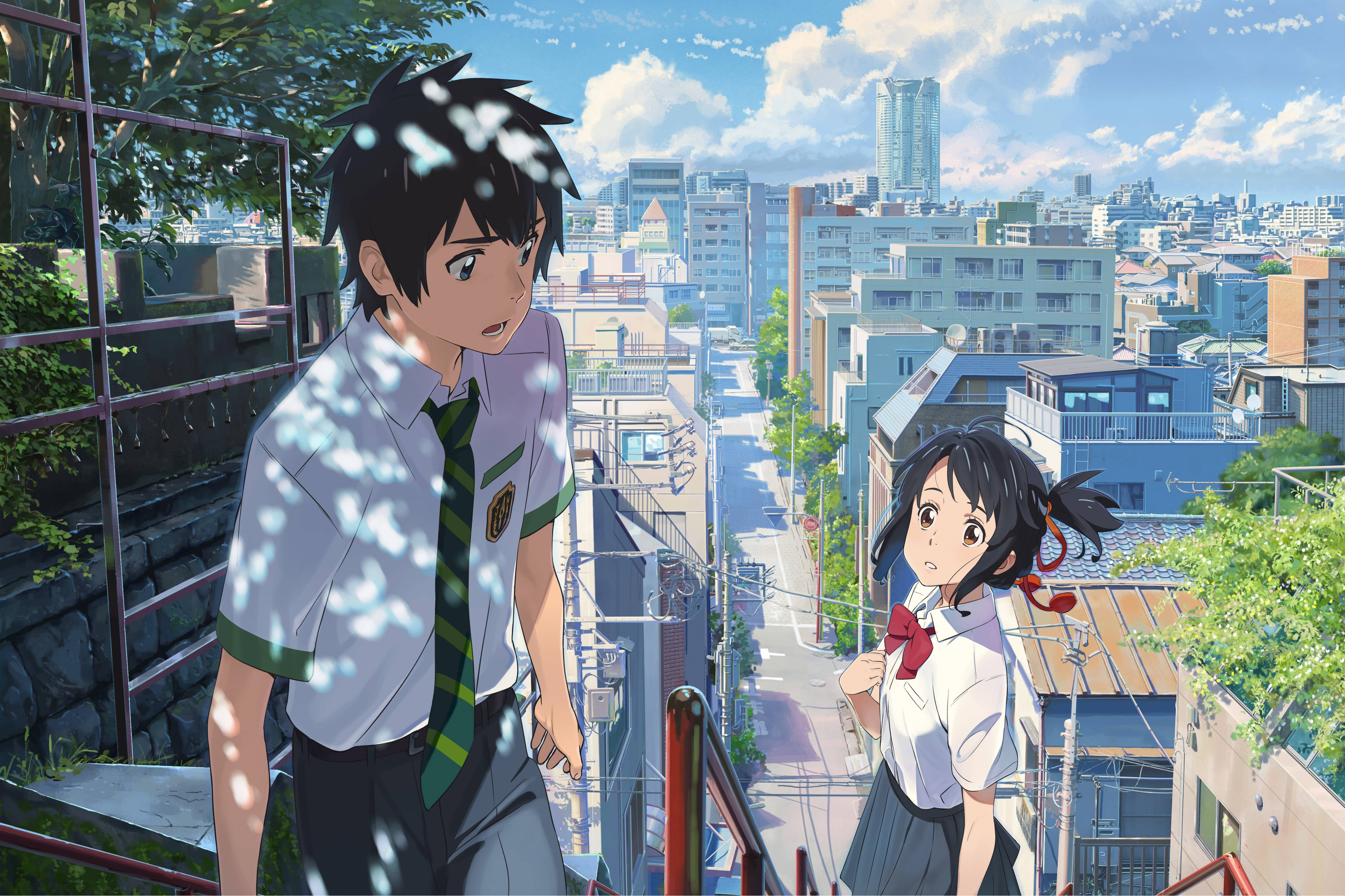 Makoto Shinkai 桌布 壁紙 — 兩名穿著校服的動畫學生站在屋頂上，俯瞰著陽光普照的城市景觀，綠意盎然，現代建築林立。