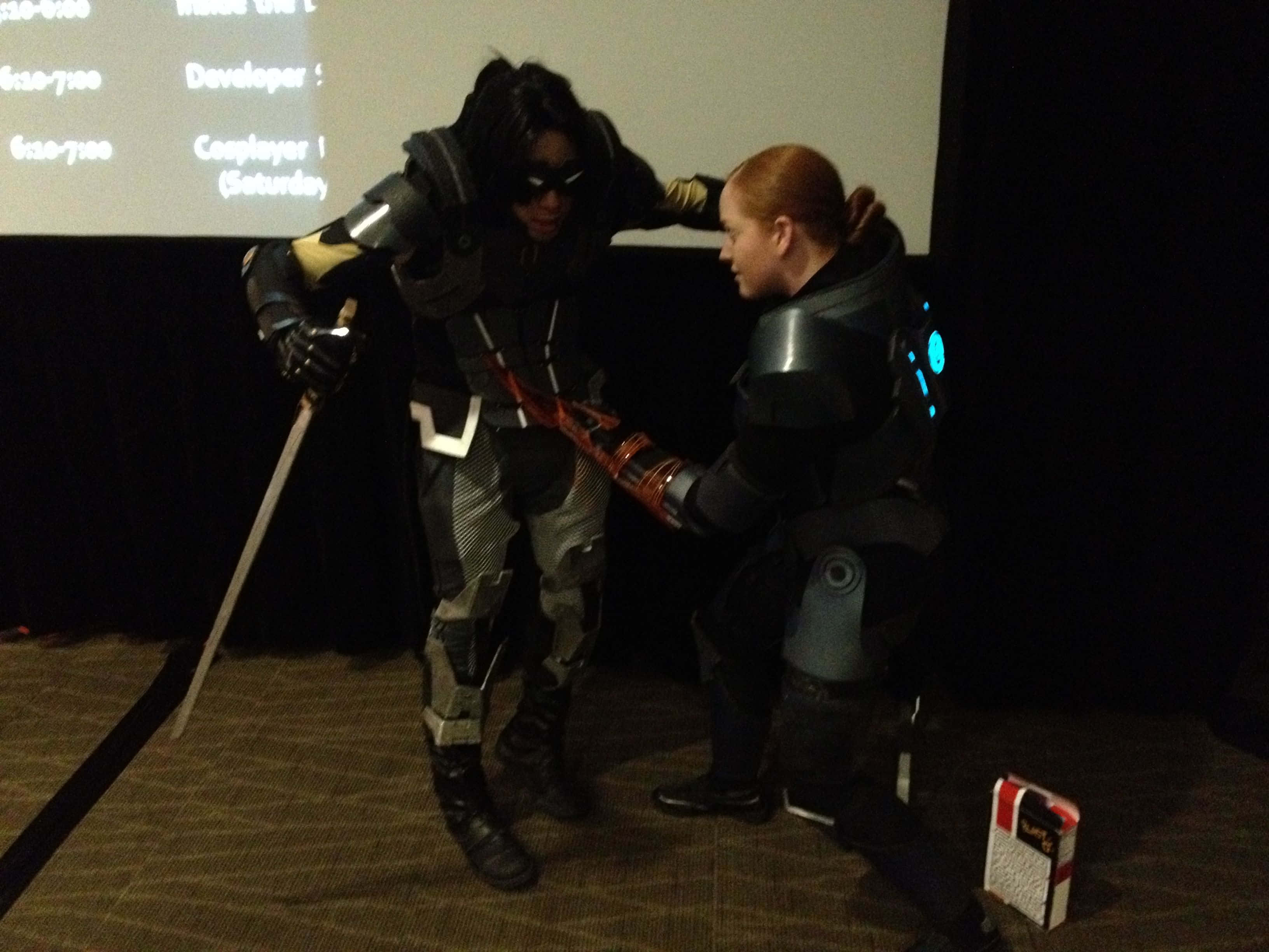 Kai Leng 桌布 壁紙 — 兩名穿著精細未來盔甲的cosplayer在昏暗的舞台上進行戲劇性的劍鬥。