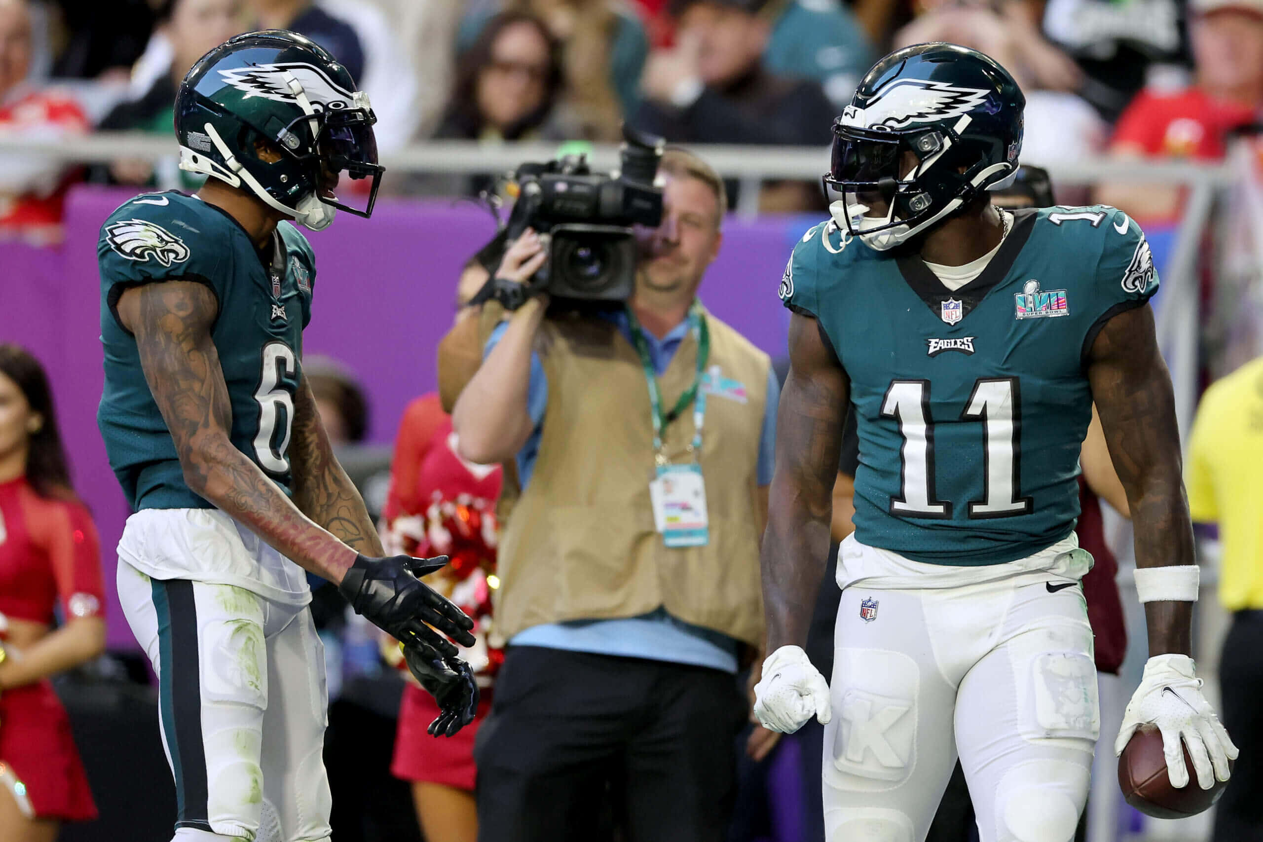 Devonta Smith 桌布 壁紙 — 兩名費城老鷹隊美式足球員在比賽期間於球場上穿著青綠色和白色裝備交換手套。