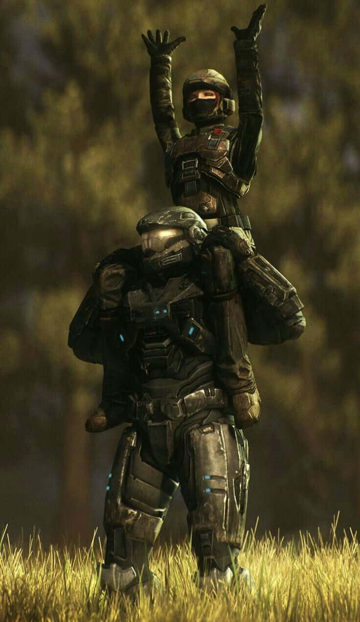 Halo Unsc 桌布 壁紙 — 兩名身穿Halo裝備的裝甲士兵，一人騎在肩上，兩人在草地上高舉雙手慶祝勝利。