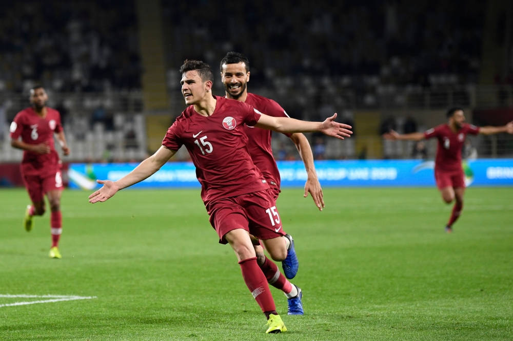 Qatar 桌布 壁紙 — 兩名身穿紅色球衣的足球運動員在體育場燈光下，於充滿活力的綠色球場上慶祝進球。