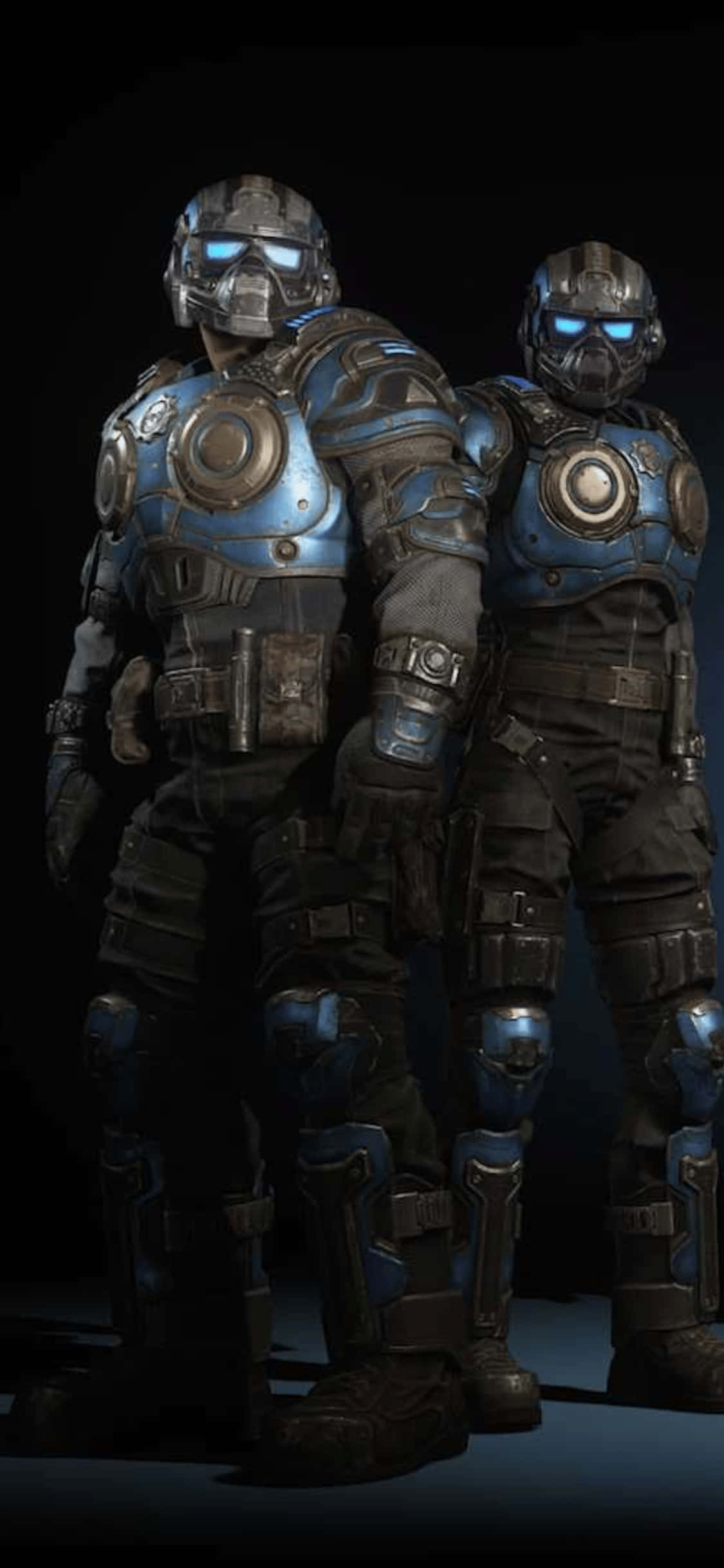 兩名身穿藍色 Gears of War 裝甲的男子並肩站立 壁紙 — 兩名身穿藍黑戰術裝備的裝甲士兵在黑暗背景前並肩站立，戴著發光的藍色護目鏡。