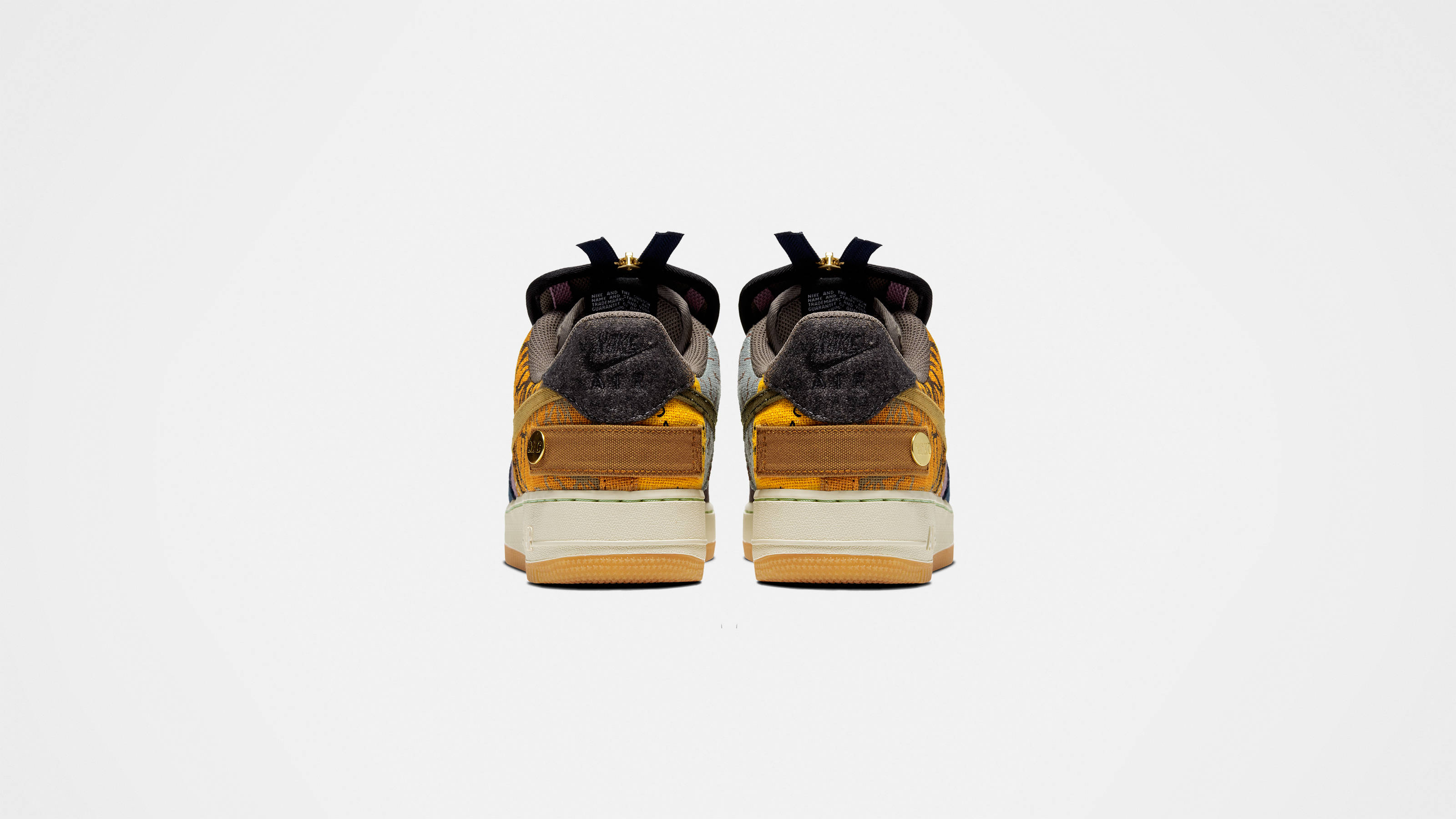 Cactus Jack x Nike Air Force 壁紙 — 兩對運動鞋從後面觀看，以純白色背景襯托，展示大膽的黃色、灰色和棕色色調。