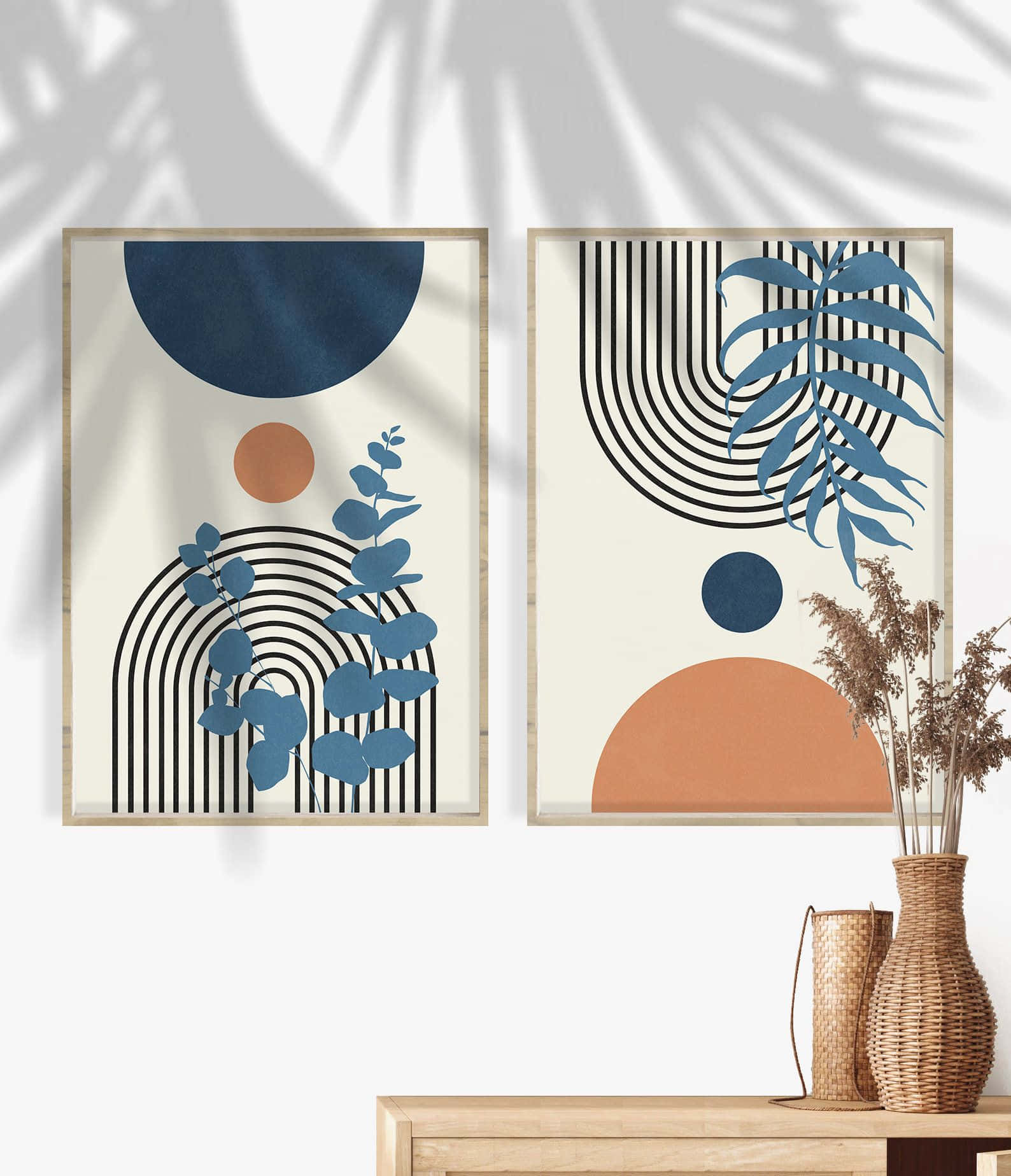 Modern Minimalist Art 桌布 壁紙 — 兩幅帶有幾何形狀和藍色葉子的裱框抽象藝術印刷品掛在白色牆上，投射出棕櫚葉的影子。