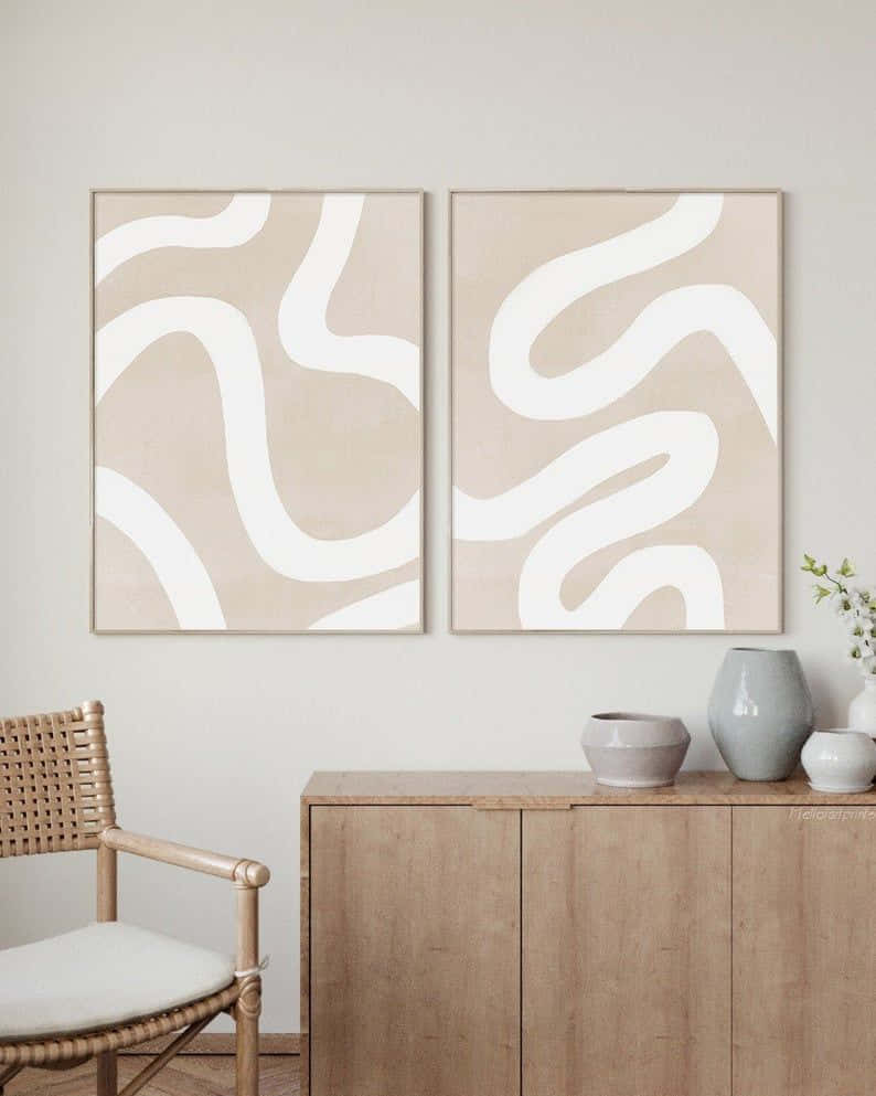 Modern Minimalist Art 桌布 壁紙 — 兩幅米色抽象藝術品，帶有白色流暢線條，掛在木櫃上方，旁邊是一張編織椅，位於簡約的起居空間中。