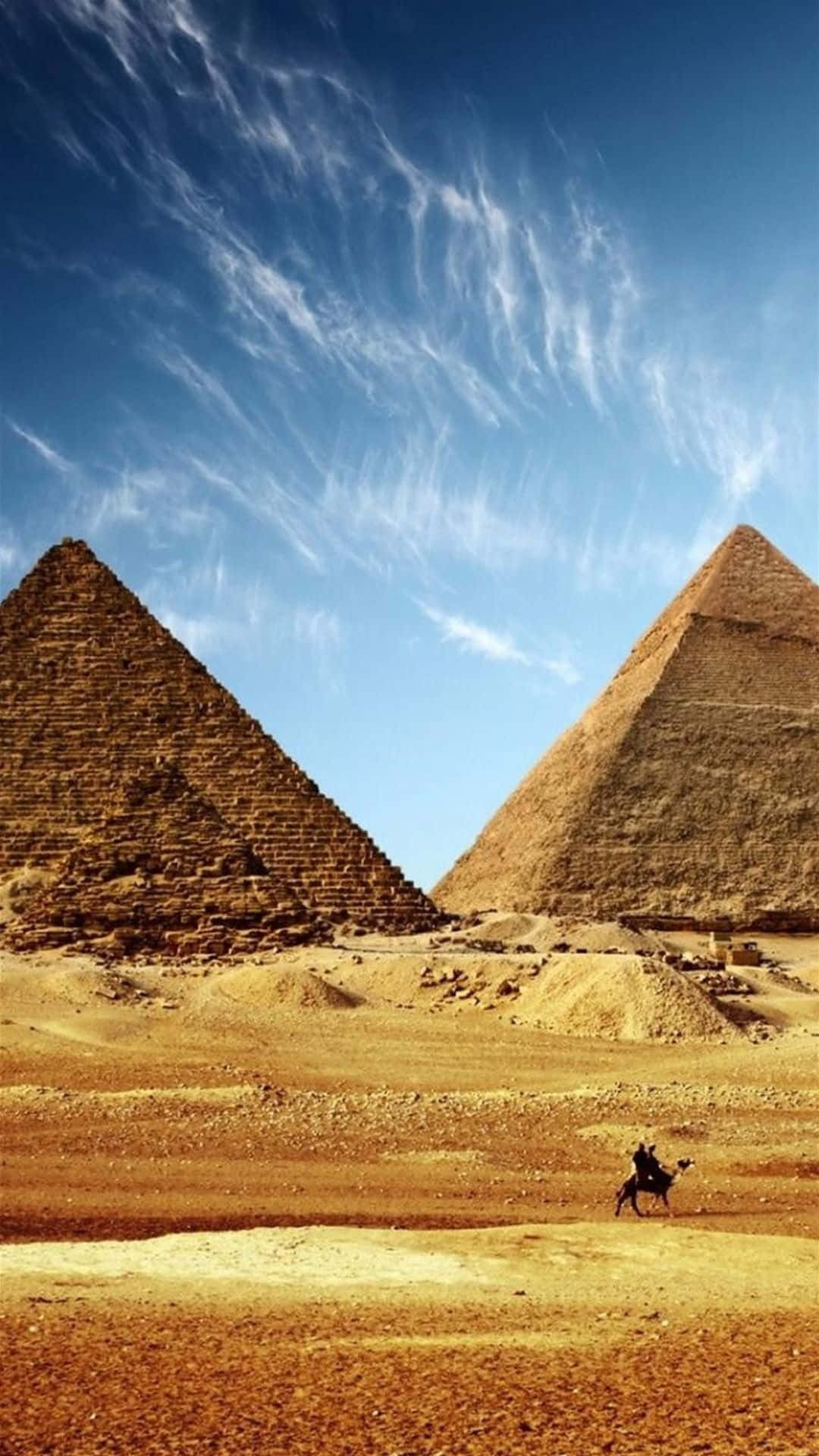 Egypt 桌布 壁紙 — 兩座巨大的古老金字塔從金色沙漠中升起，在廣闊的藍天下，天空點綴著縷縷薄雲。