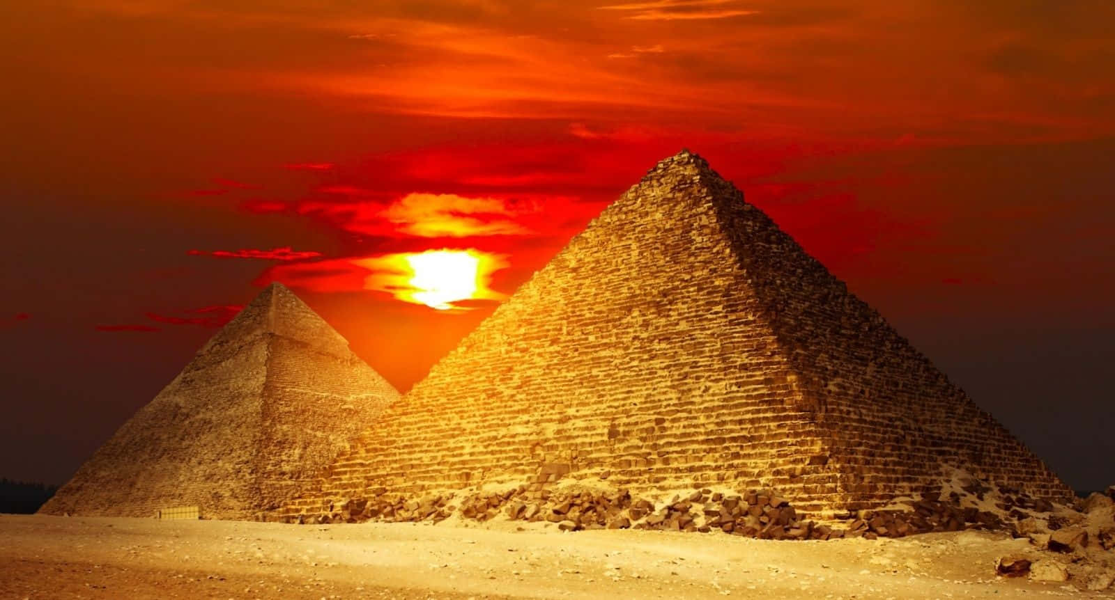 Egypt 桌布 壁紙 — 兩座巨大的金字塔在火紅的夕陽天空和發光的太陽映襯下呈現剪影。