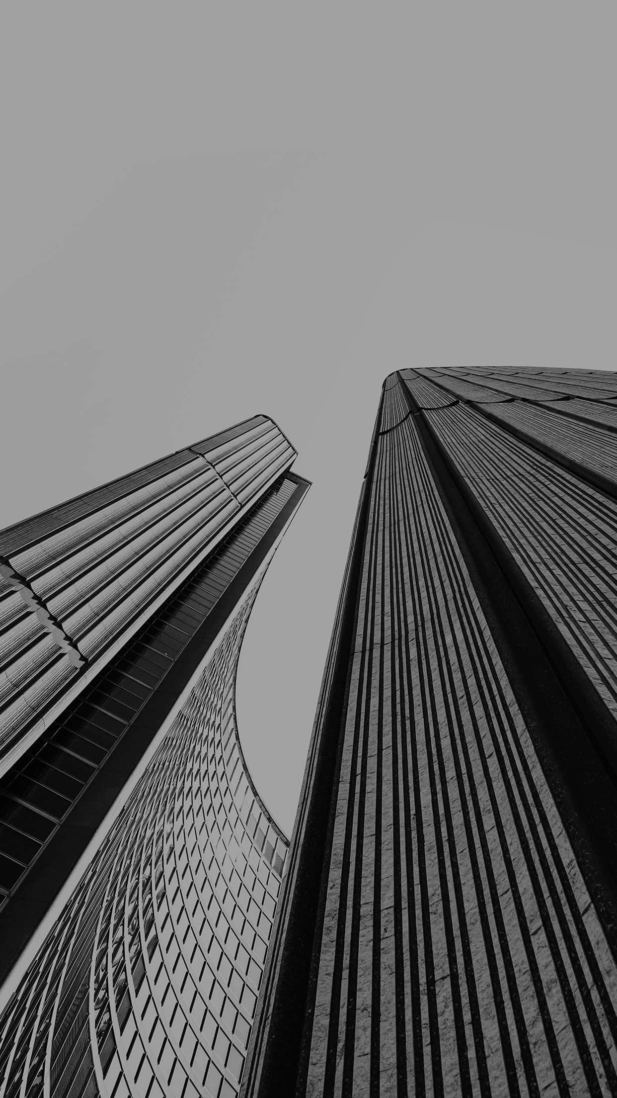 Black And White Architecture 桌布 壁紙 — 兩座高聳入雲的摩天大樓在樸素的天空背景下，以鮮明的黑白構圖戲劇性地崛起。