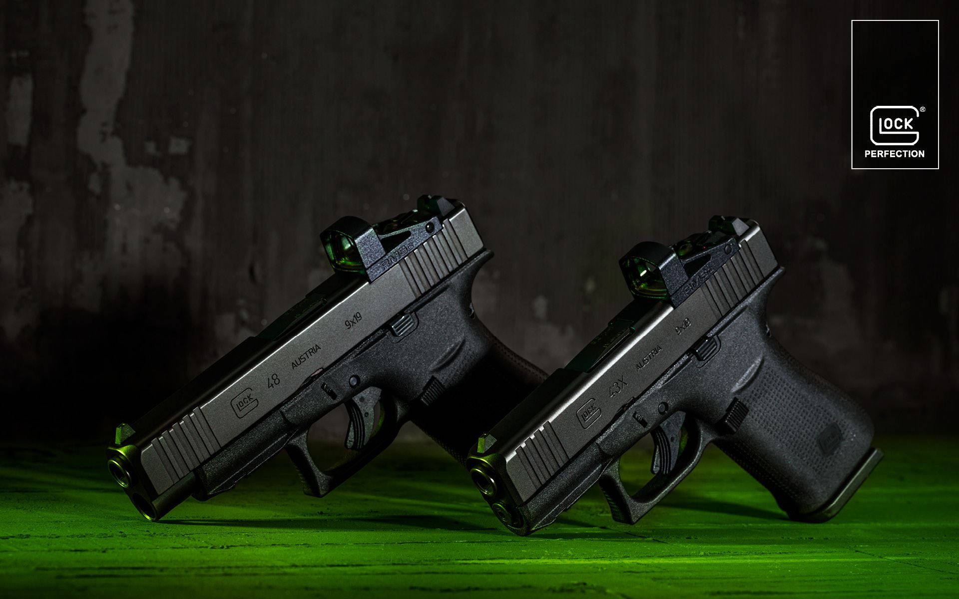 兩把黑色 Glock 手槍帶有綠色發光瞄準器在綠色表面上。