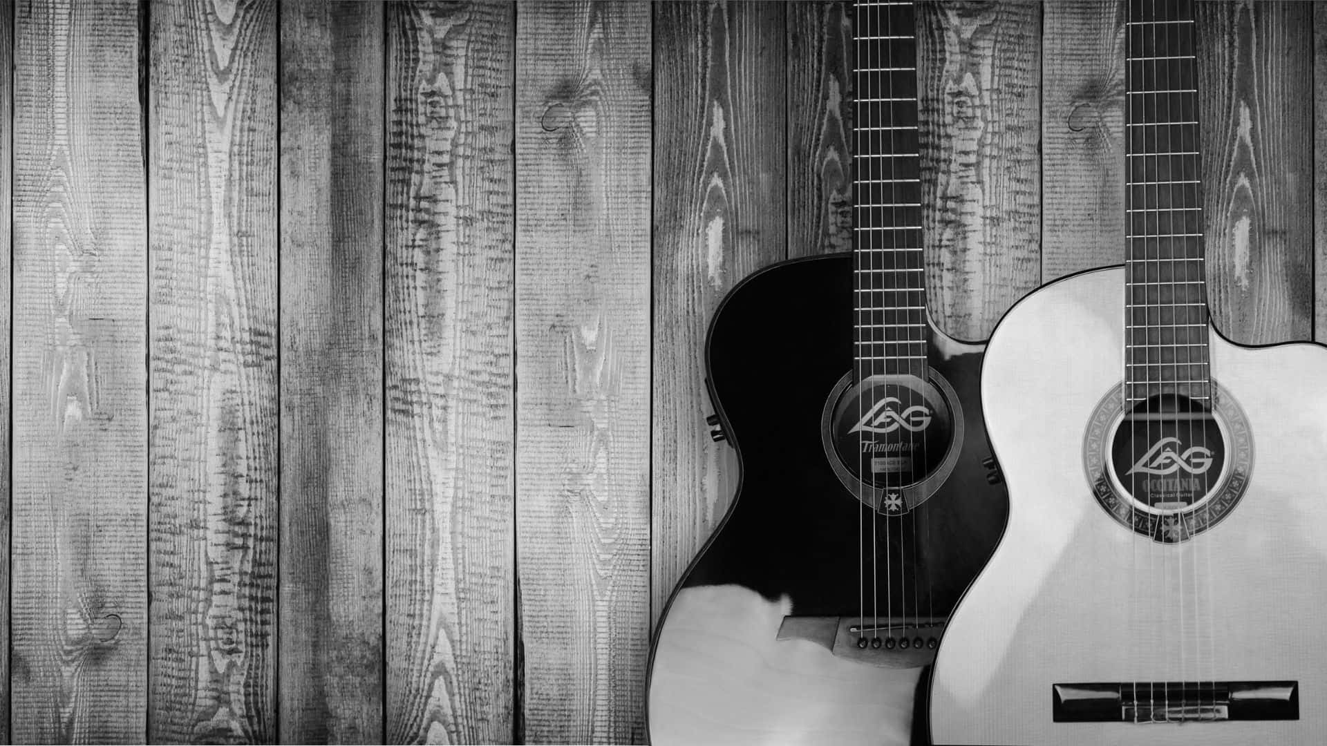 Black And White Guitar 桌布 壁紙 — 兩支原聲結他，一黑一白，靠喺風化嘅木板上，呈現單色調。