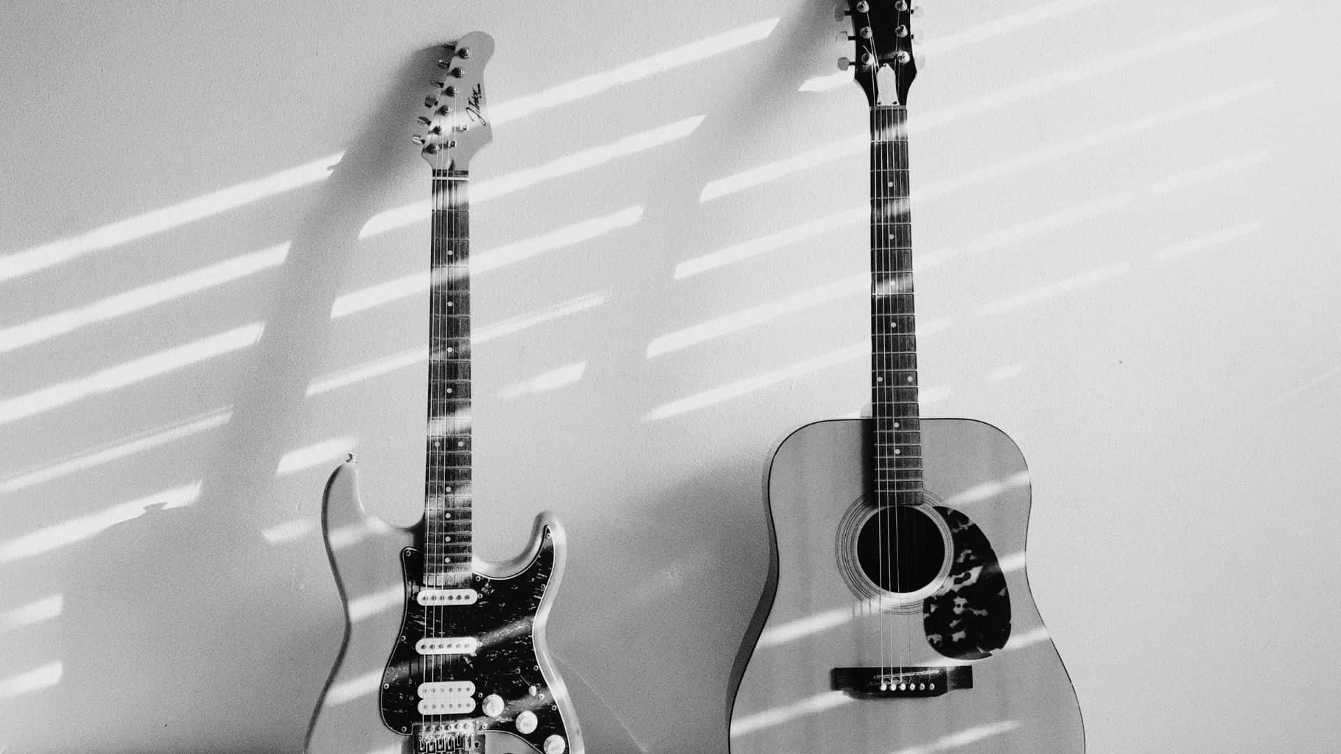 Black And White Guitar 桌布 壁紙 — 兩支結他靠牆而立，沐浴在強烈條紋陽光下，投射出戲劇性的陰影。