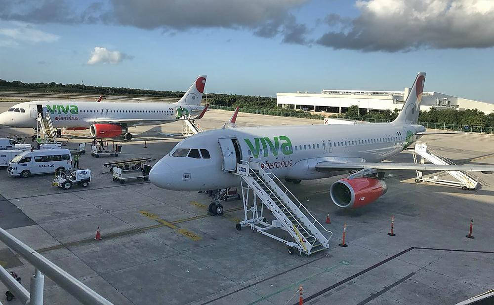 Viva Aerobus飛機停在機場閘口，配有登機樓梯和地勤服務車輛。