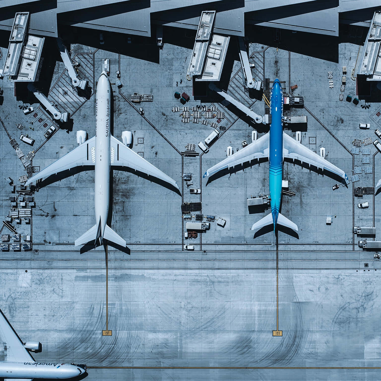 Aviation 桌布 壁紙 — 兩架大型飛機停泊在機場閘口，設有登機橋及停機坪設備的航拍圖。