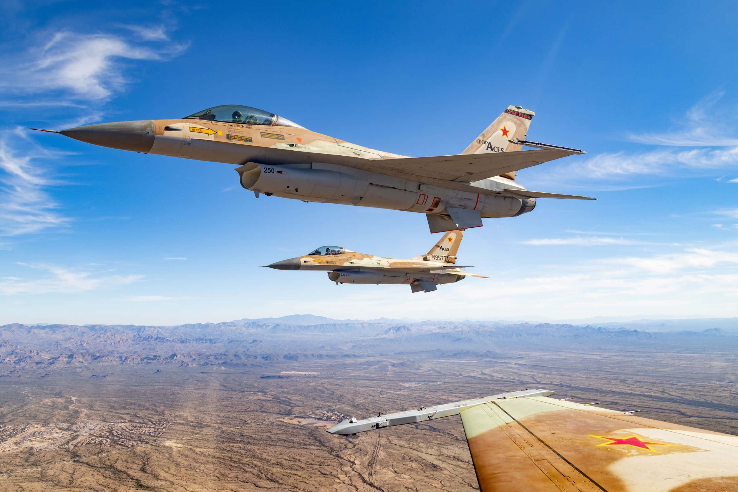 Air Force 桌布 壁紙 — 兩架戰鬥機在晴朗藍天和薄雲下，於廣闊沙漠景觀上空編隊飛行。