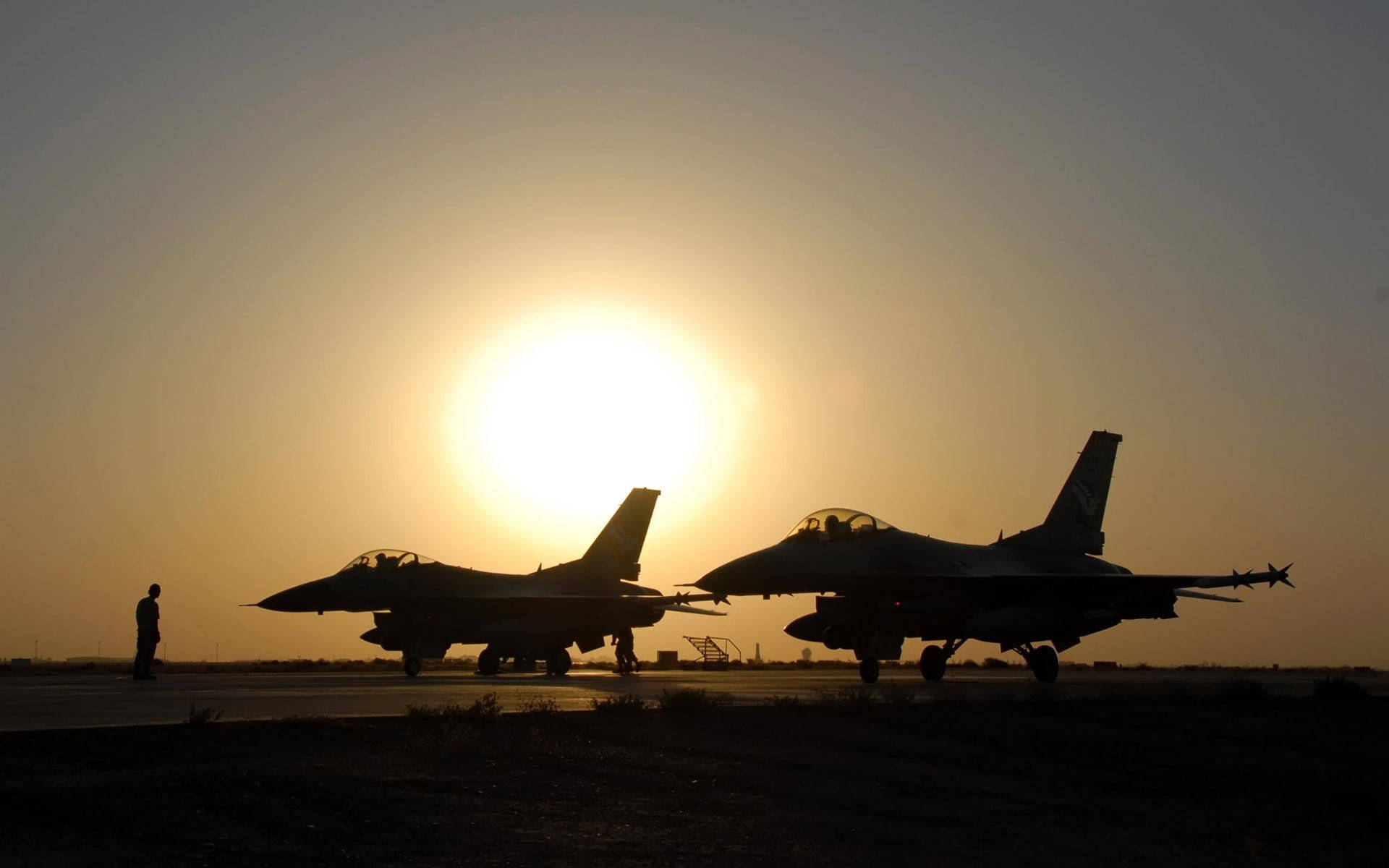 機場上夕陽映襯下的兩架戰鬥機剪影。 — 軍事動圖 壁紙