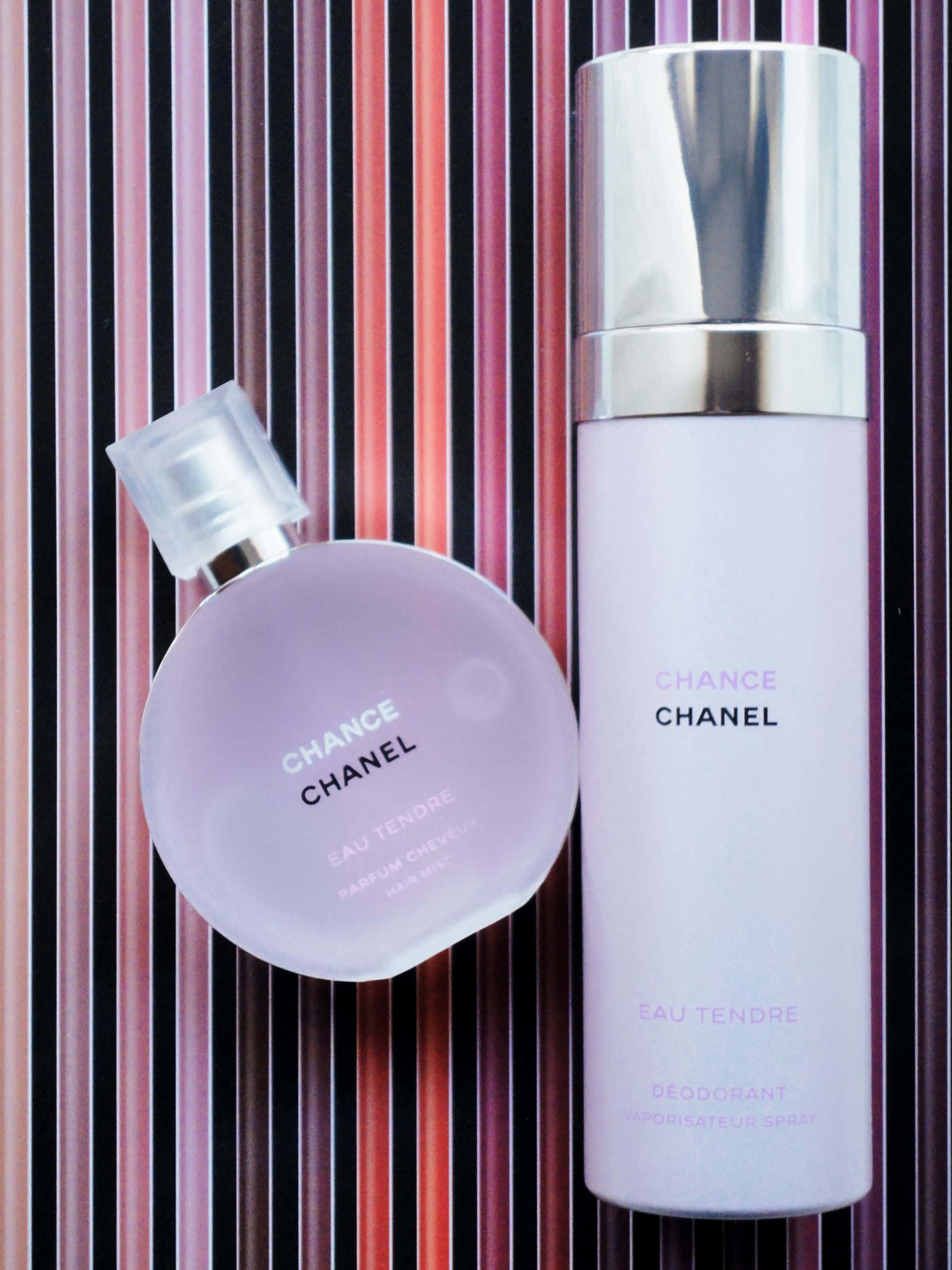 Spring Perfume 桌布 壁紙 — 兩款 Chanel Chance Eau Tendre 產品倚靠在粉紅、紫色和黑色的鮮豔條紋背景上。