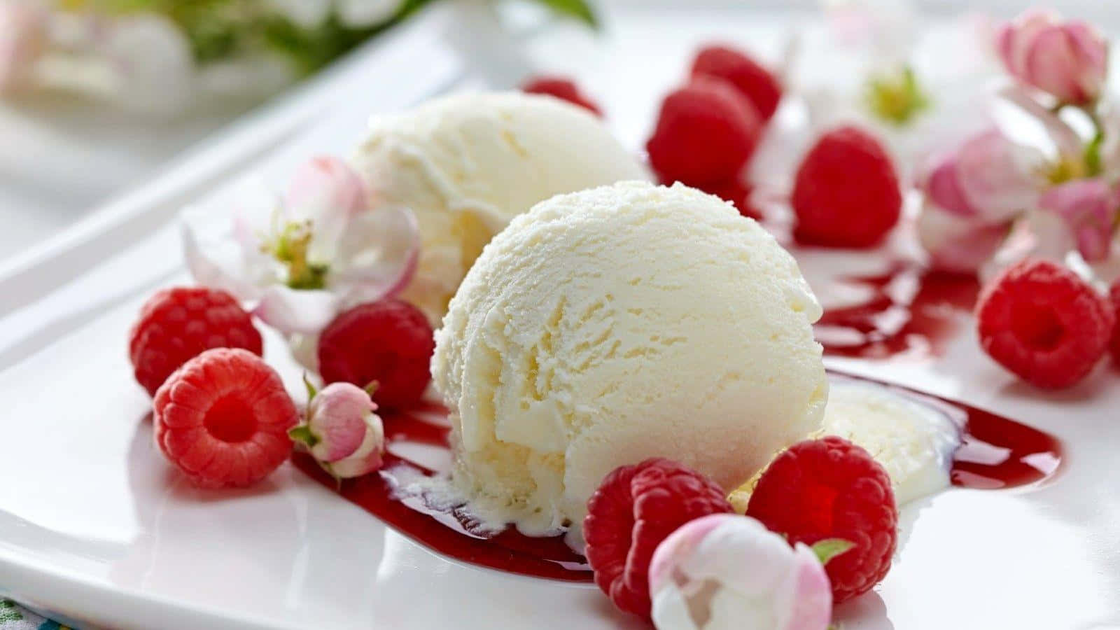Ice Cream 桌布 壁紙 — 兩球奶油香草雪糕，伴以新鮮紅桑子和精緻粉紅花朵，置於白色碟上。
