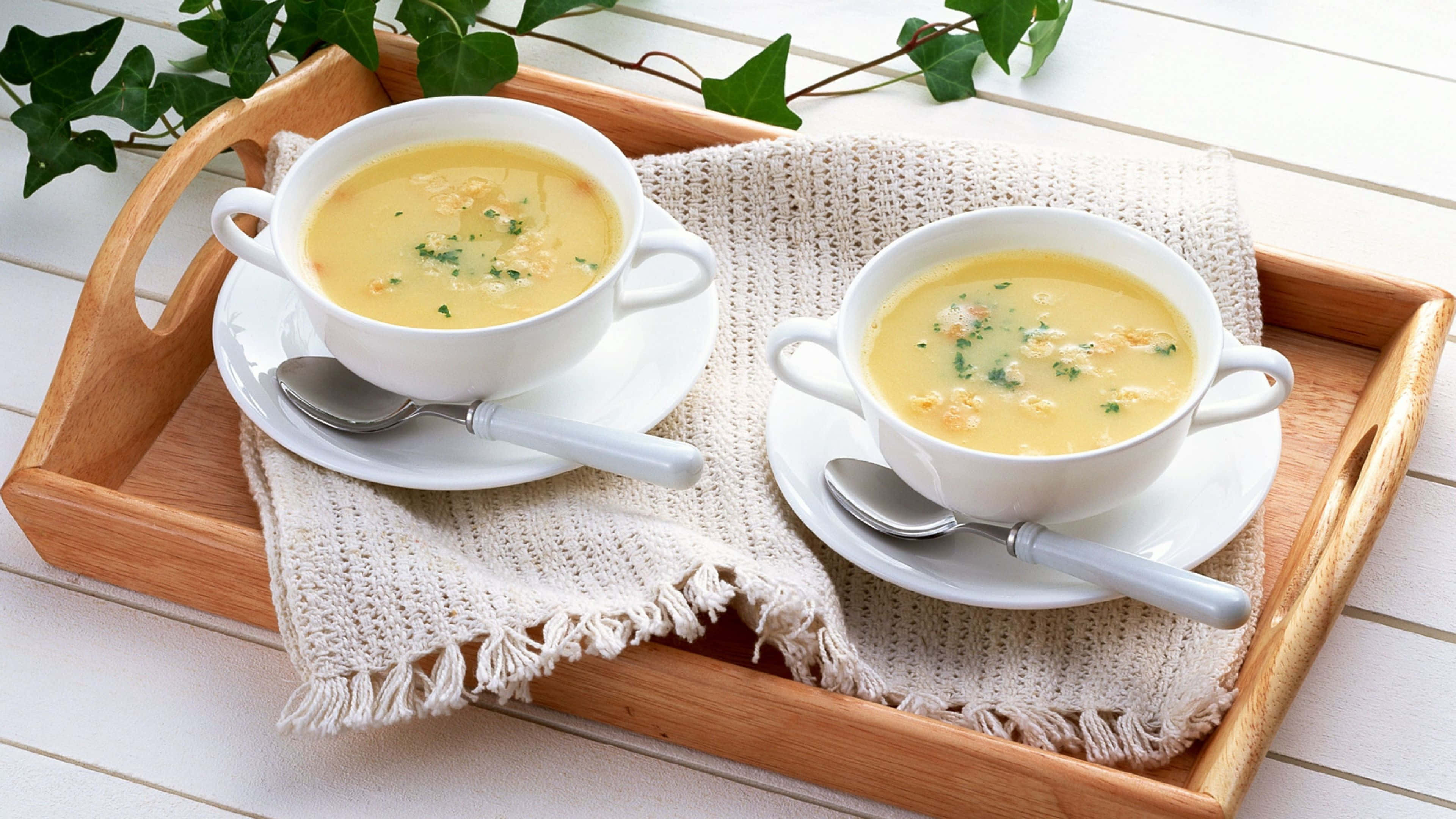 Soup 桌布 壁紙 — 兩碗奶油黃色湯，飾以綠色香草，放在鋪有紋理米色布的木托盤上。