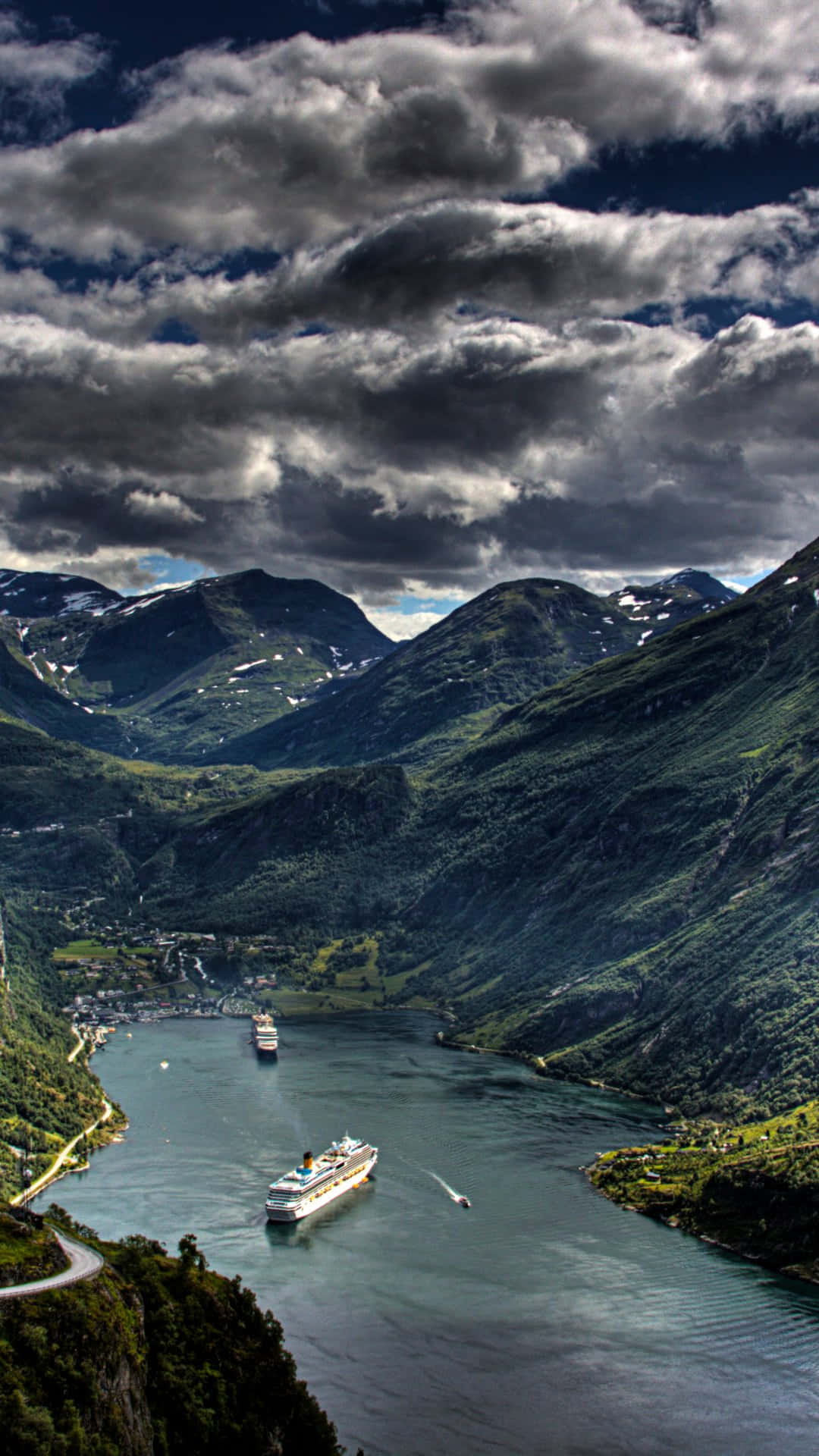 Norway 桌布 壁紙 — 兩艘郵輪在戲劇性的多雲天空下，滑行於兩旁高聳綠山的深邃峽灣中。