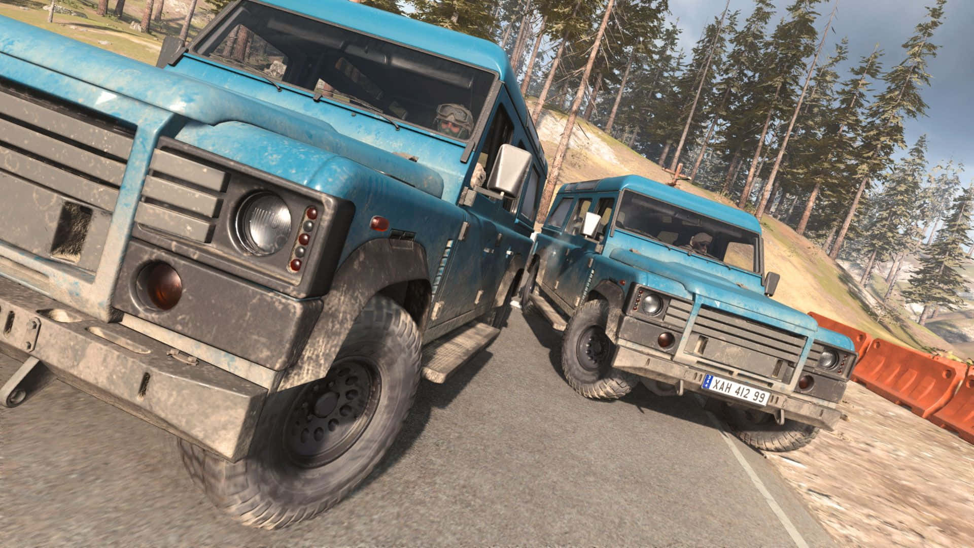 Call Of Duty Vehicles 桌布 壁紙 — 兩輛堅固的藍色越野車在森林道路上相撞，背景有松樹和橙色障礙物。