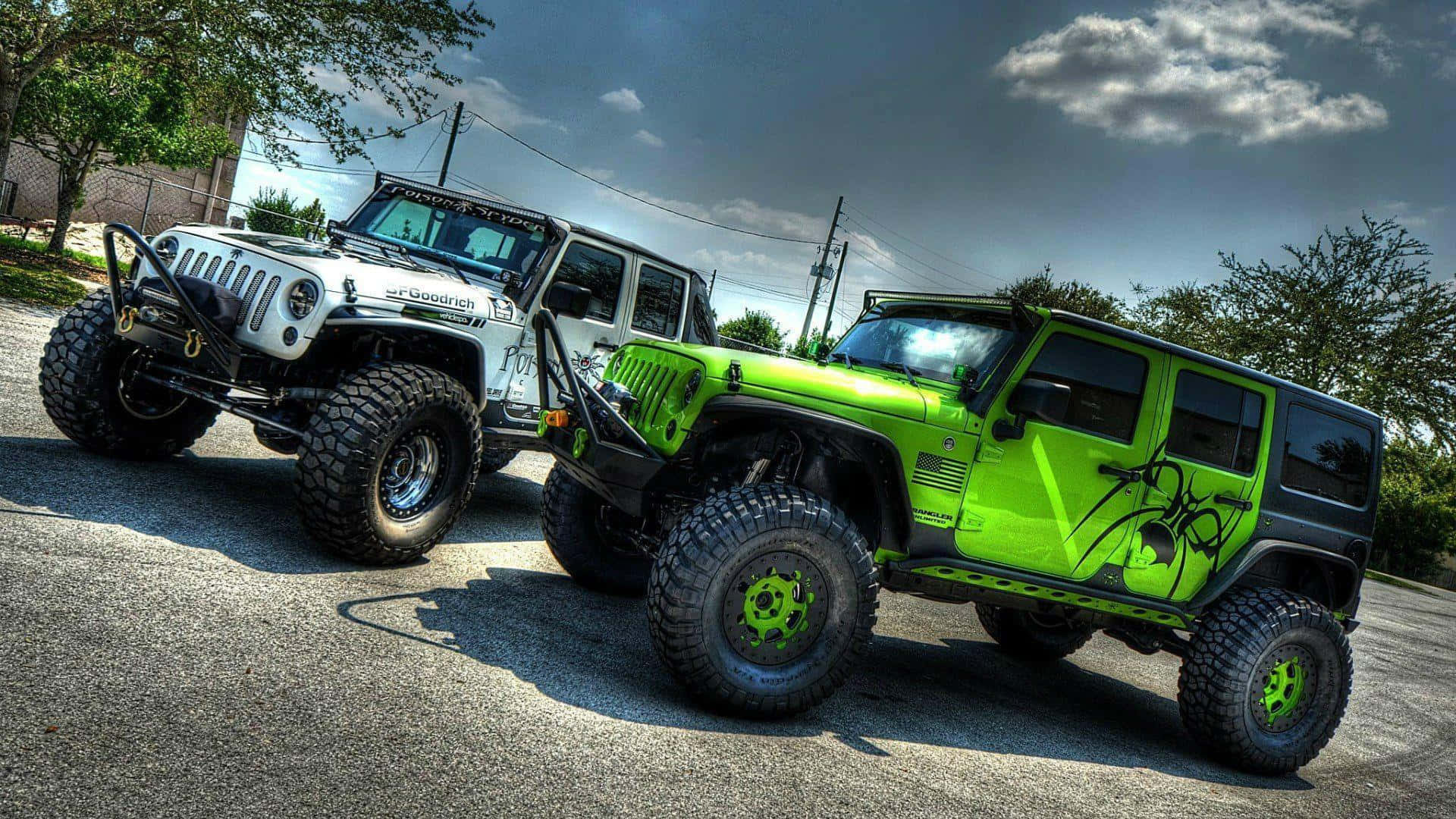 Jeep 動圖 桌布 壁紙 — 兩輛定制越野吉普車，一輛白色，一輛螢光綠色，停在陰天下的瀝青路面上。