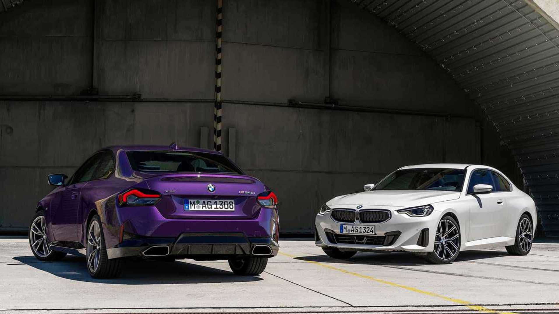 Bmw 2 Series 桌布 壁紙 — 兩輛時尚的BMW雙門轎跑車，一輛充滿活力的紫色，一輛純淨的白色，停放在混凝土機庫內。