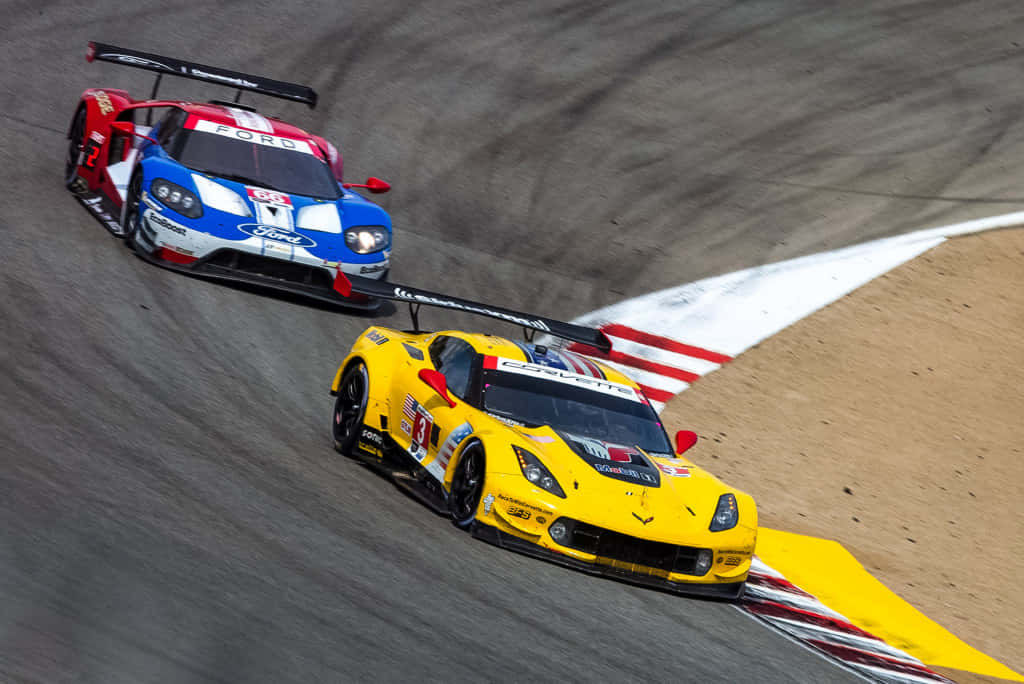 Car Racing 桌布 壁紙 — 兩輛賽車在陽光明媚的賽道上激烈角逐，賽道設有紅、白、黃三色路緣。