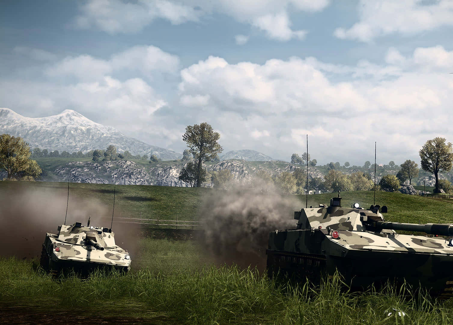 Battlefield Vehicles 桌布 壁紙 — 兩輛迷彩裝甲車在陰天背景下，穿過草地，揚起塵土，背景是白雪覆蓋的山脈。