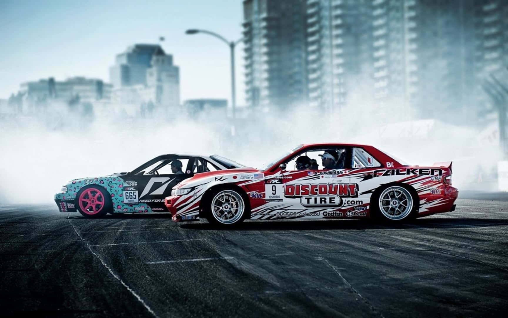 JDM 車 桌布 壁紙 — 兩輛飄移車在煙霧瀰漫的都市街道上並肩競速，背景是高樓大廈。