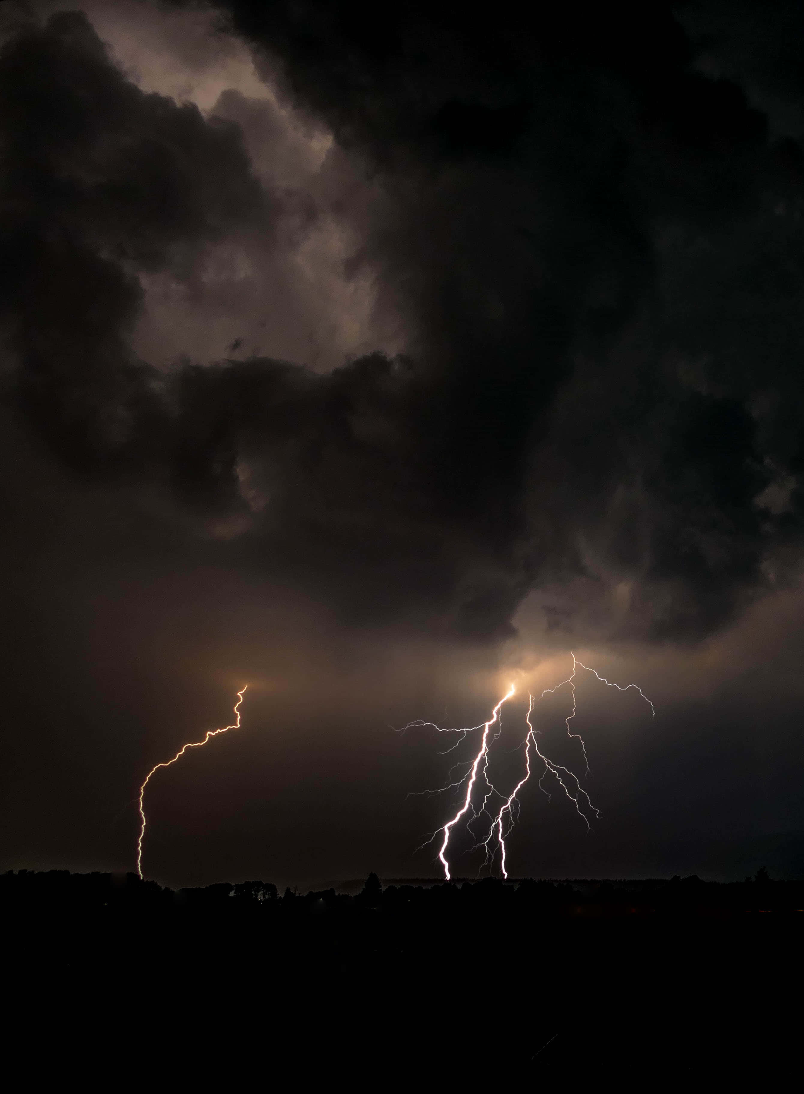 暴風 桌布 壁紙 — 兩道鋸齒狀閃電劃破暴風雨夜空中遠處山丘的黑色剪影。