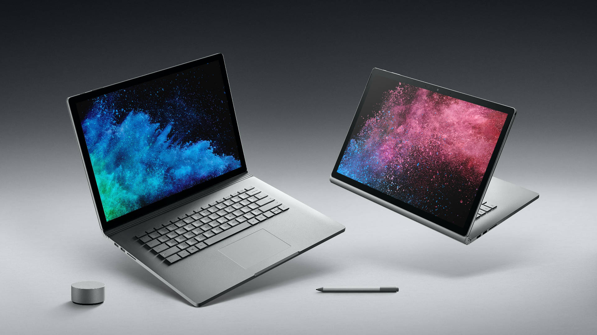 microsoft 桌布 壁紙 — 兩部時尚的銀色手提電腦懸浮著，屏幕上閃耀著充滿活力的藍色和粉紅色宇宙塵埃壁紙。