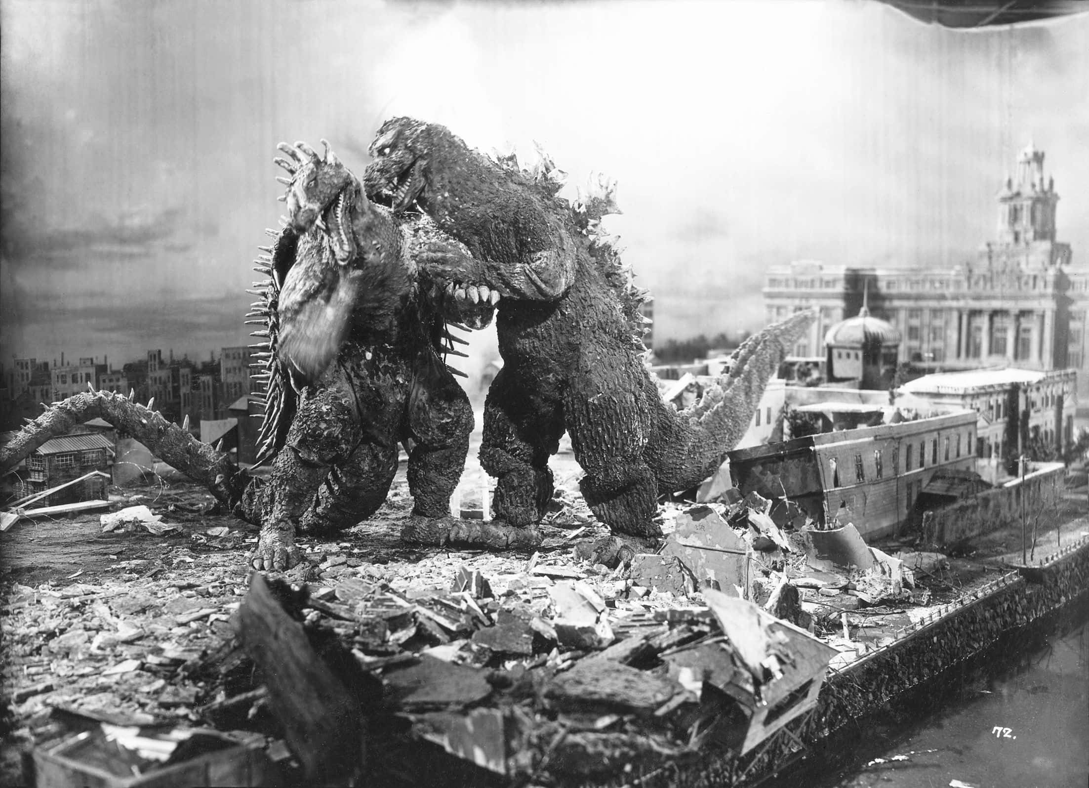 Godzilla 1954 桌布 壁紙 — 兩隻巨型怪獸喺經典黑白電影劇照中，喺被摧毀嘅城市景觀中嘅瓦礫中碰撞。