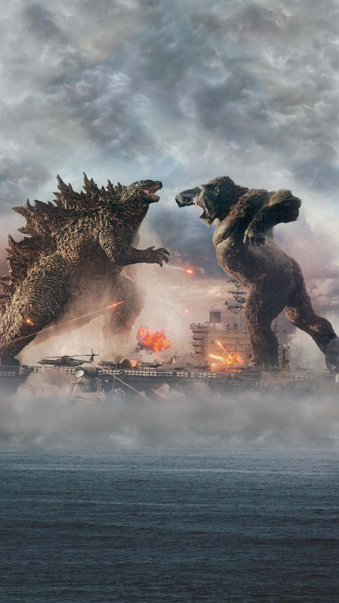 Godzilla Vs Kong 桌布 壁紙 — 兩隻巨大怪獸哥斯拉和金剛在風暴肆虐的大海和熾熱爆炸中，於一艘燃燒的航空母艦上激戰。