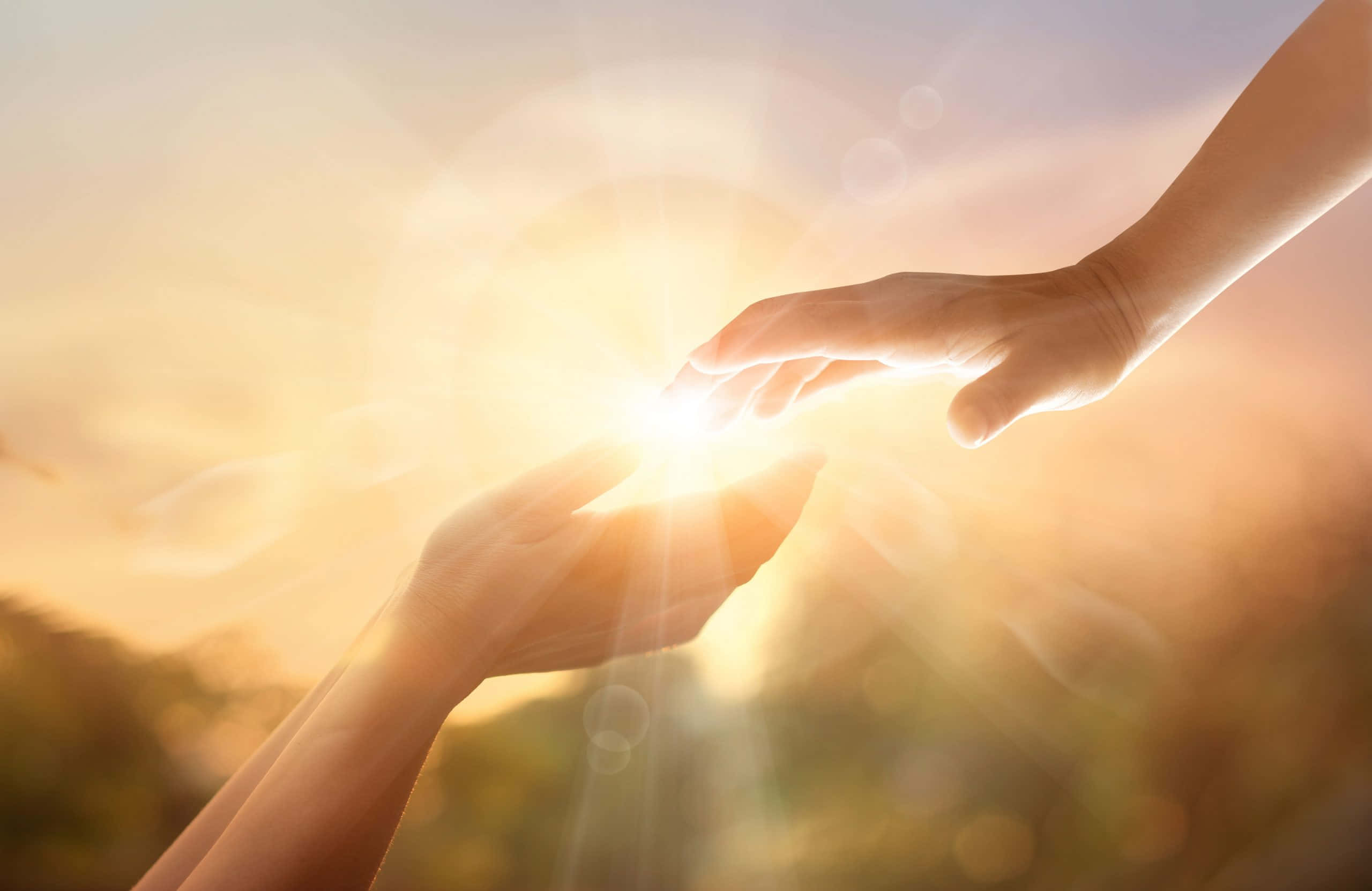 hands 桌布 壁紙 — 兩隻手互相伸向對方，陽光在它們之間迸發，營造出溫暖發光的效果。