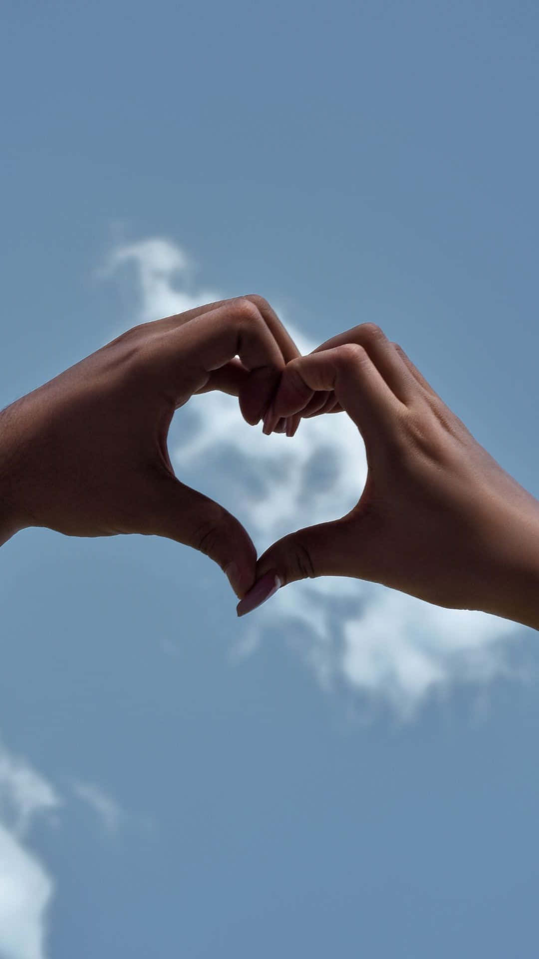 Beautiful Love 桌布 壁紙 — 兩隻手在清澈的藍天和柔軟的白雲前形成一個心形。