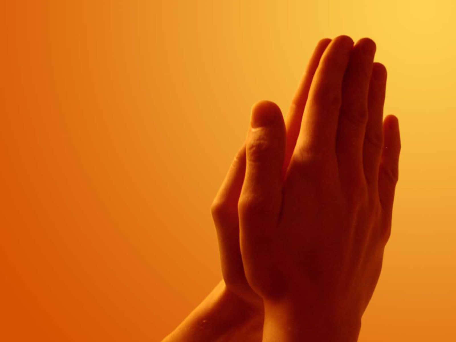 Praying 桌布 壁紙 — 兩隻手在溫暖的橙色漸變背景前合十祈禱。