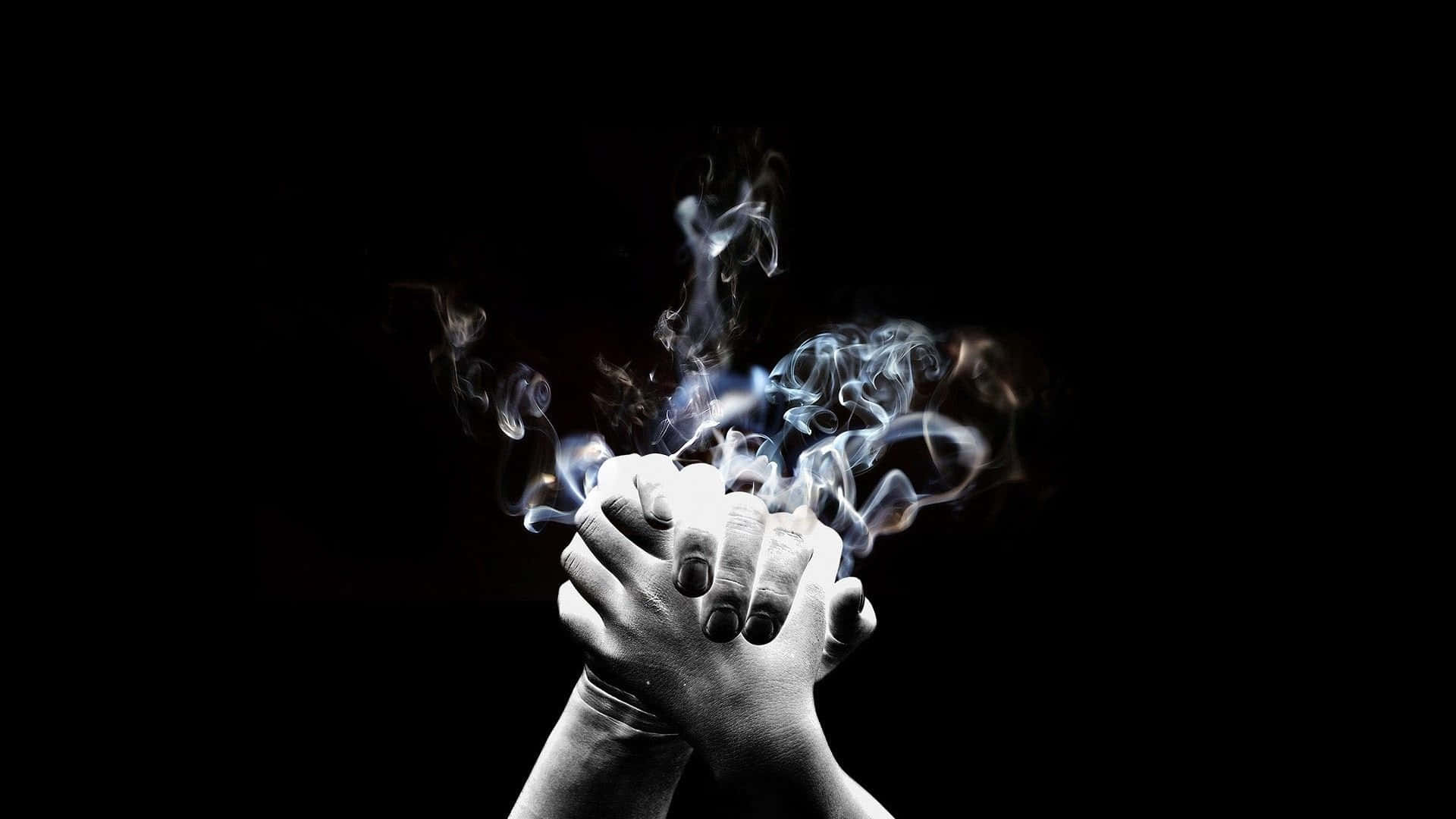 Dark Hand 桌布 壁紙 — 兩隻手在黑色背景上緊緊相握，之間有旋轉的藍色煙霧升起。
