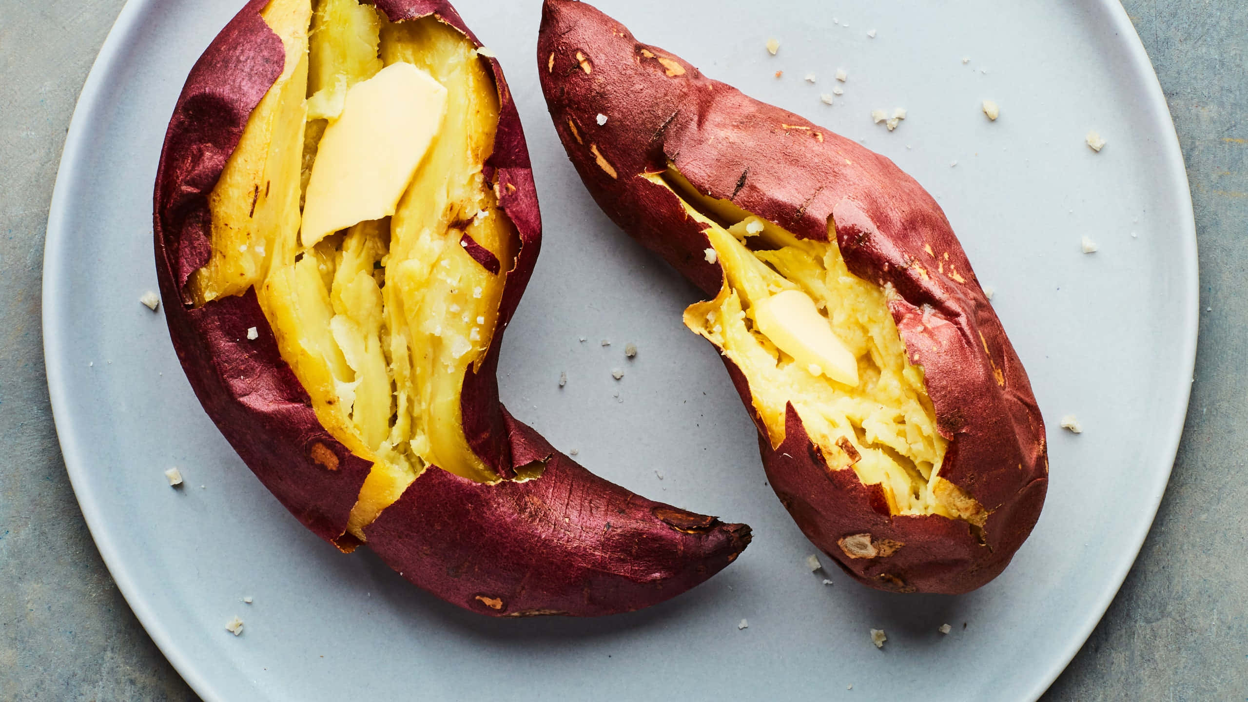 Yellow Sweet Potato 桌布 壁紙 — 兩隻烤番薯在碟上切開，露出鬆軟黃色果肉，上面放有融化牛油和薄片鹽。