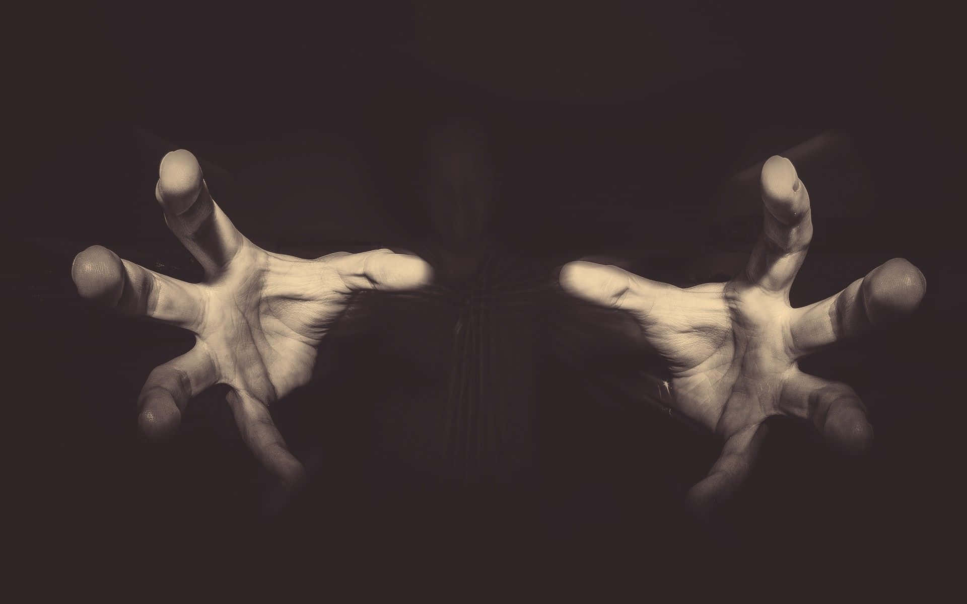 Dark Hand 桌布 壁紙 — 兩隻蒼白的手張開手指，在戲劇性的明暗對比燈光下，向黑暗背景伸出。