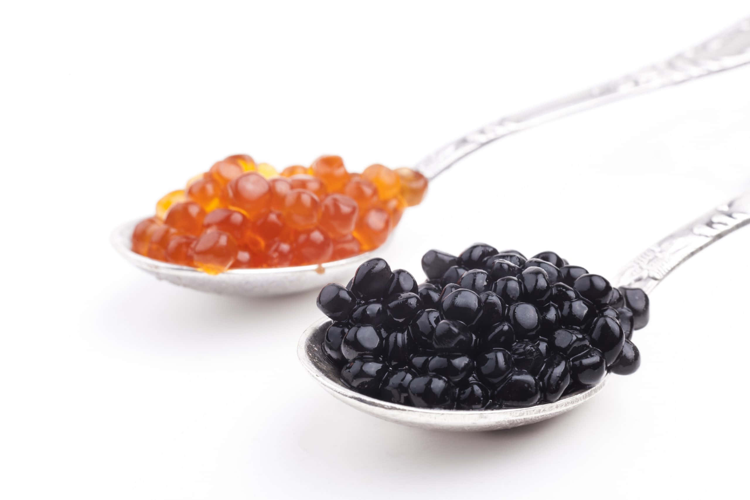 Black Caviar 桌布 壁紙 — 兩隻銀匙盛載著鮮橙色和亮黑色嘅魚子醬，襯托喺純白背景上。