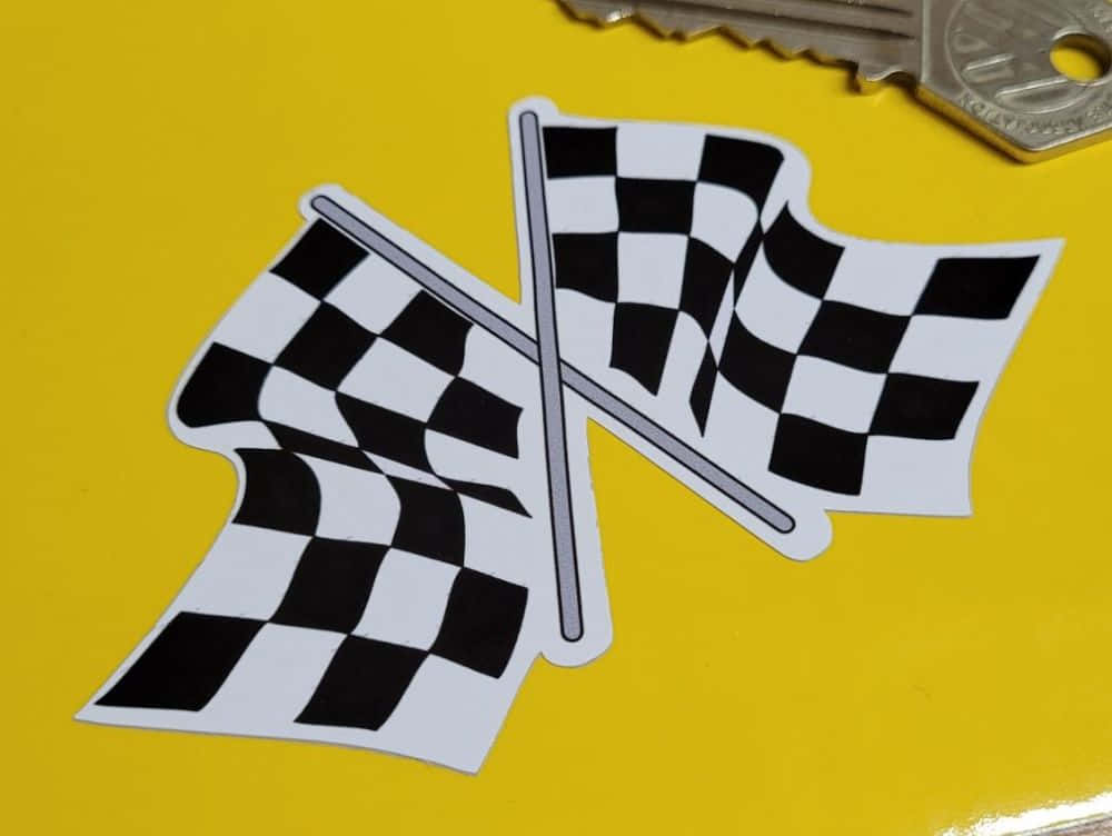 Chequered Flag 桌布 壁紙 — 兩面黑白格仔賽車旗交叉放在鮮黃色表面上，附近有一串鑰匙。