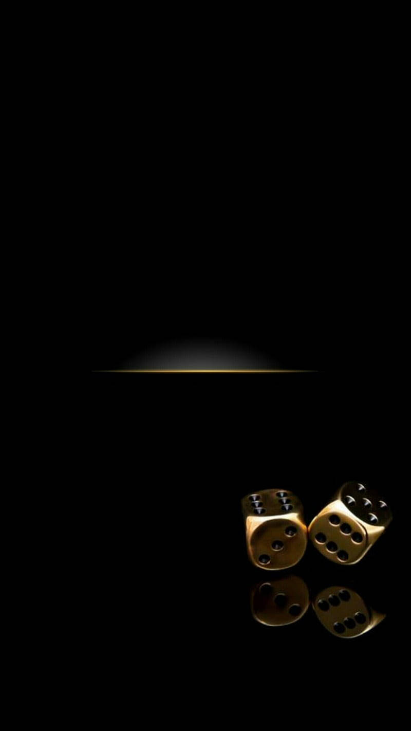 Dice 桌布 壁紙 — 兩顆閃閃發光的金色骰子放在黑色背景下的聚光燈下的反光表面上。
