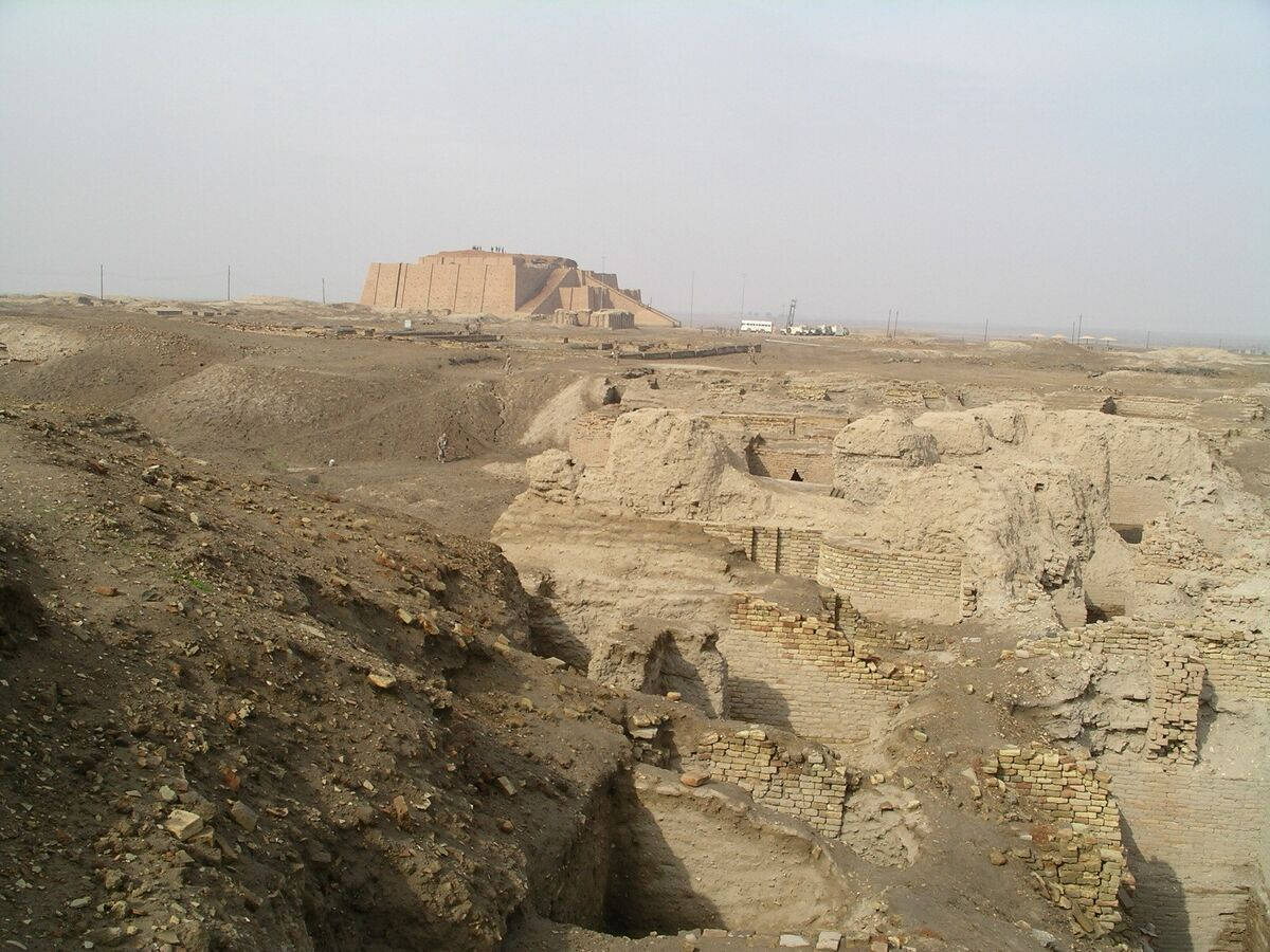 沙漠景觀中的古代金字形神塔遺跡，散落著磚地基。