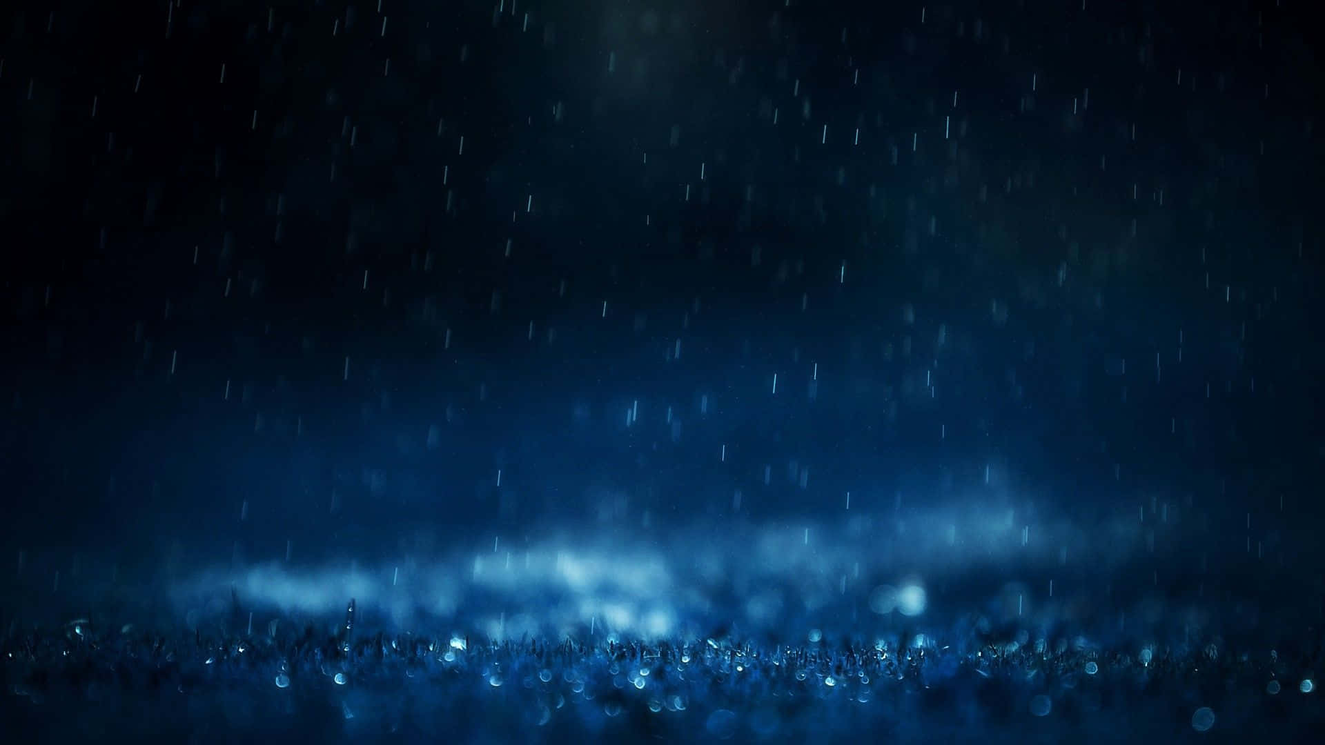 深藍色的夜晚下雨，靠近地面有發光的薄霧。