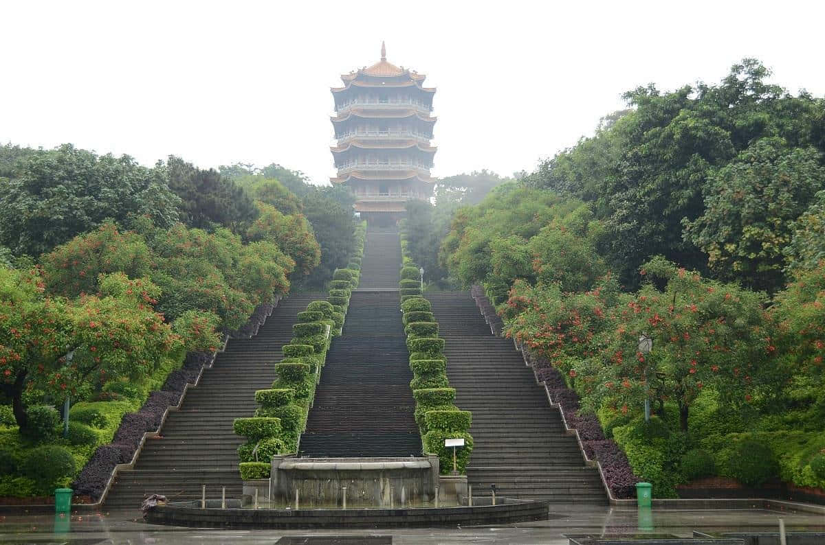 一座寶塔位於長樓梯頂端，周圍環繞著綠樹和灌木。