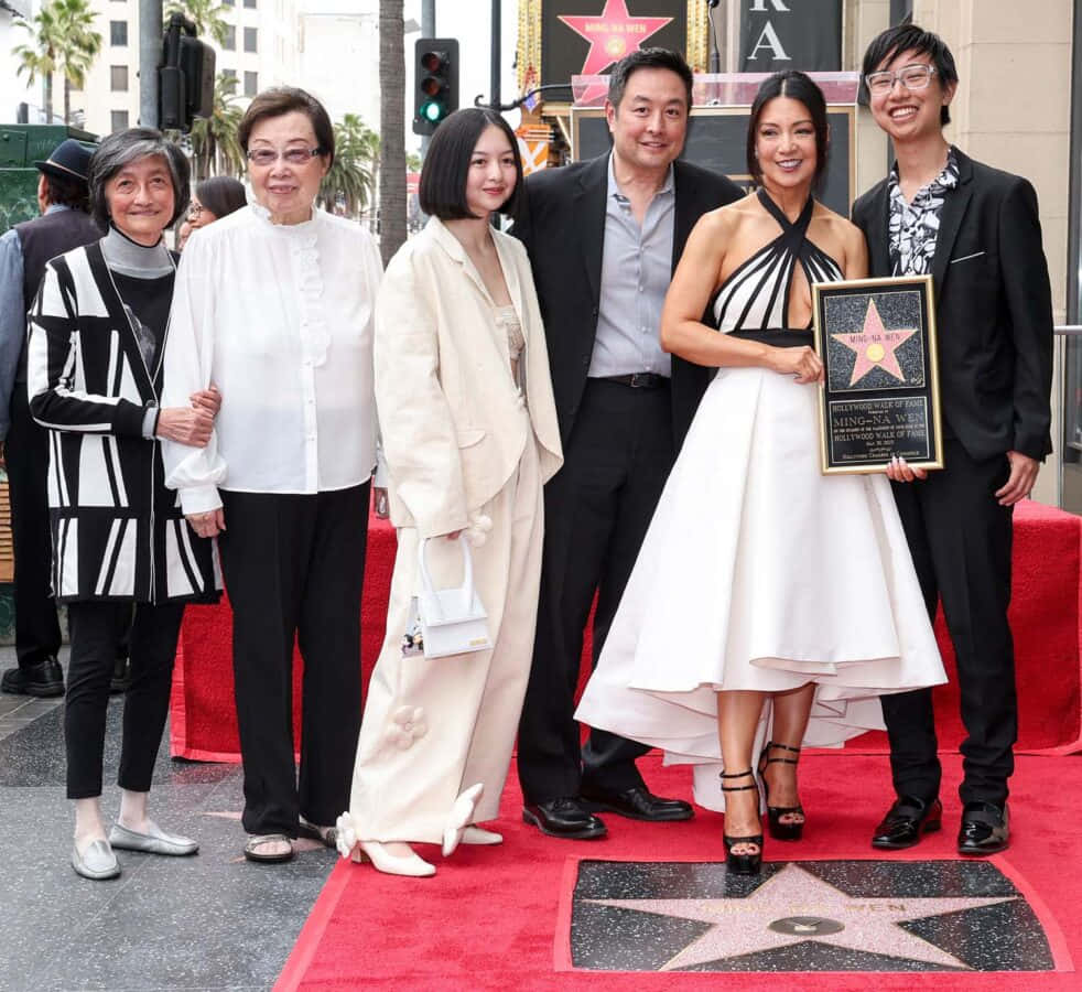 Ming Na Wen 桌布 壁紙 — 六人組在荷里活星光大道的星星旁紅地毯上擺姿勢，一位身穿白色連衣裙的 smiling 女士手持牌匾。
