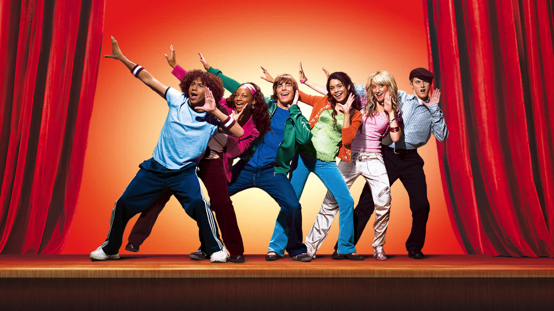 High School Musical 桌布 壁紙 — 六位充滿活力的表演者在溫暖橙色燈光下，於紅色帷幕環繞的木製舞台上擺出動感姿勢。
